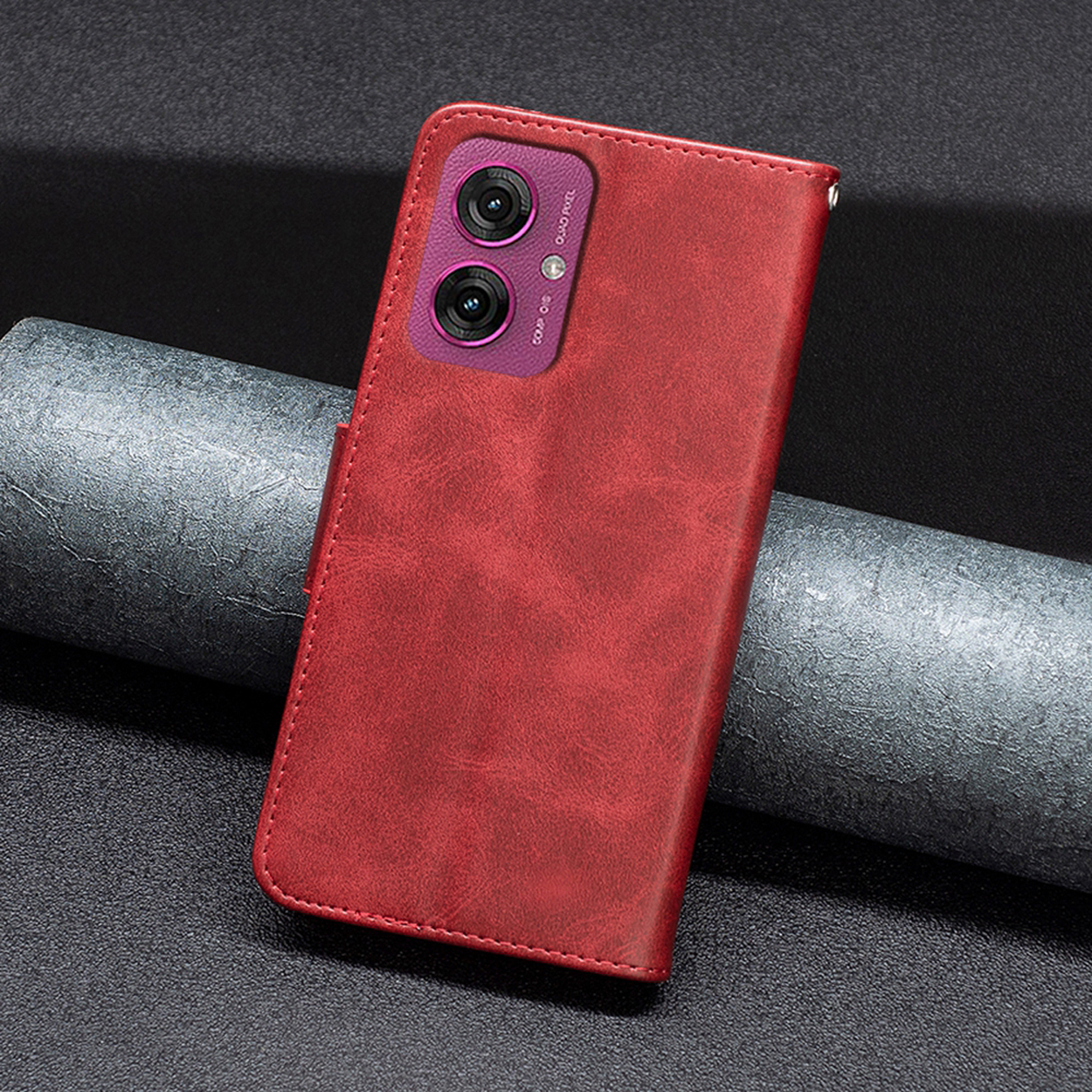 Rode leren telefoonhoes. De hoes is gesloten. Een metalen cilinder staat op de achtergrond.