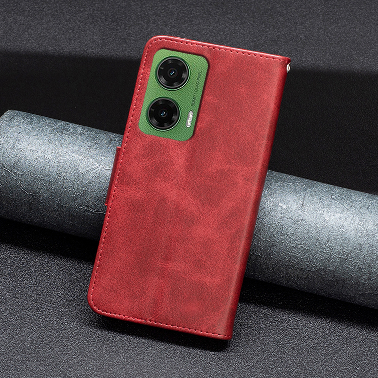 Étui de téléphone rouge fermé. Le dos a deux lentilles de caméra. L'étui est sur une surface grise.
