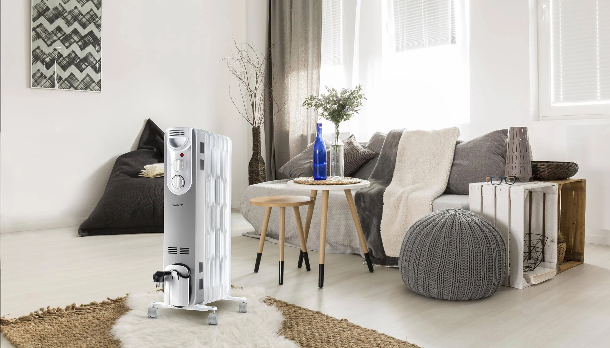 Salon z białym grzejnikiem, sofą, stołem i pufą. Pokój ma nowoczesny design.