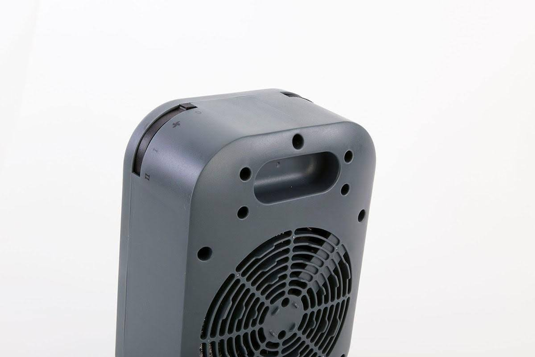 Widok z tyłu szarego grzejnika elektrycznego pokazujący wentylator i uchwyt z przełącznikiem.