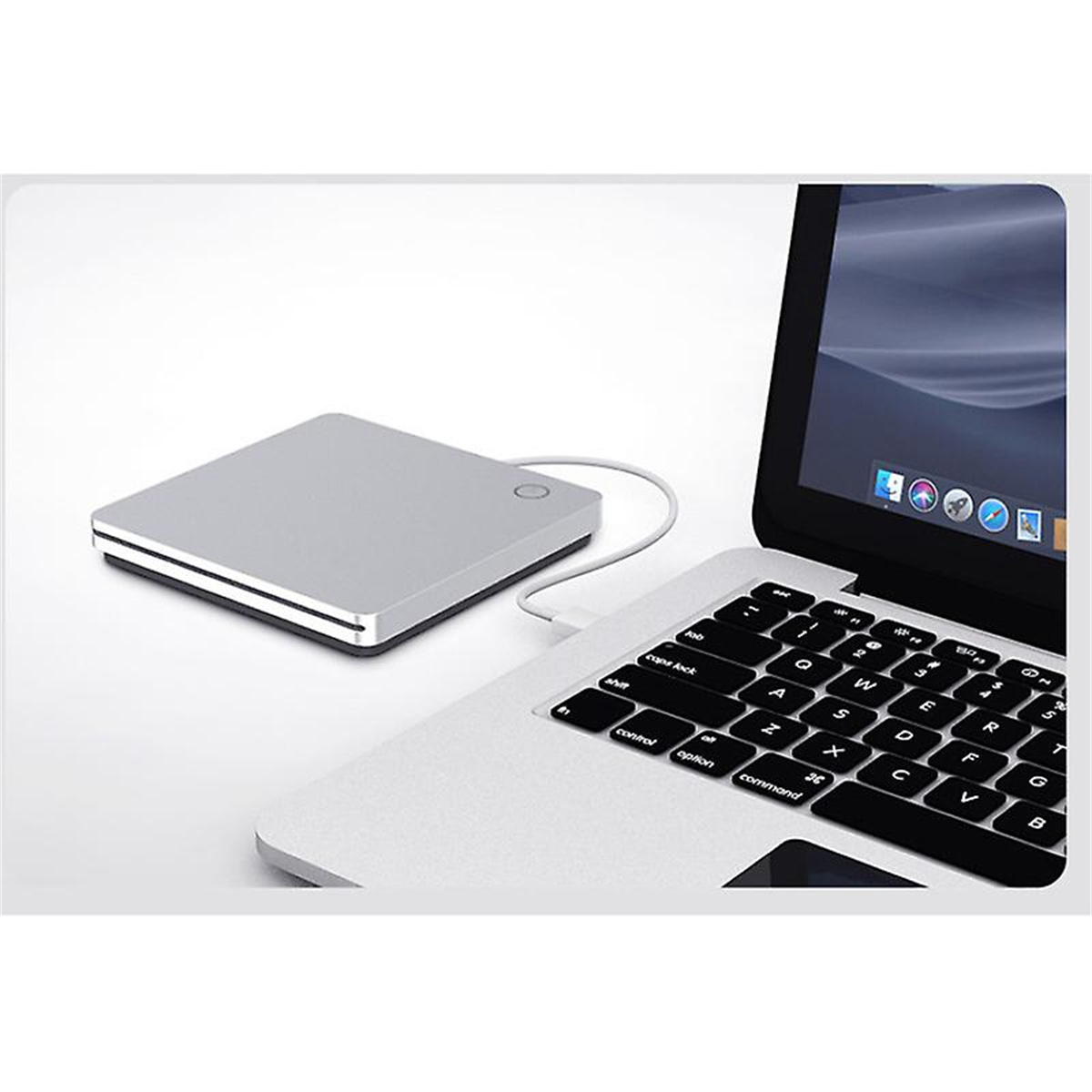 Eine silberne externe Festplatte, die an einen Laptop angeschlossen ist. Der Laptop ist geöffnet.