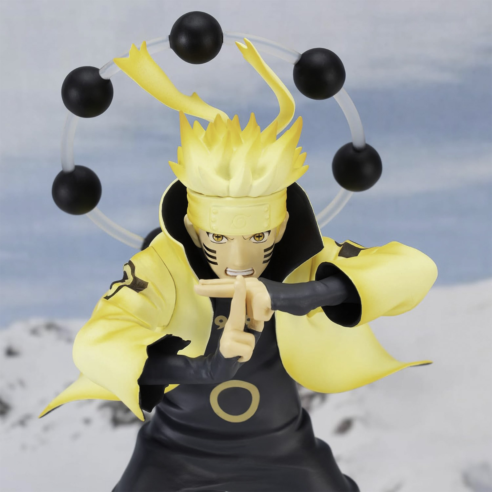 Figura de anime Naruto en pose dinámica. Colores amarillo y negro. Fondo blanco.