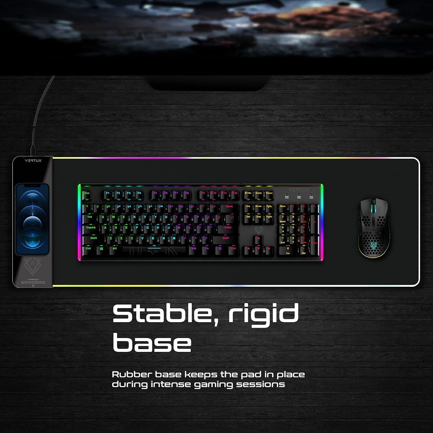 Un teclado y un ratón negros sobre una alfombrilla negra y gris. El texto dice 'Base estable y rígida'.
