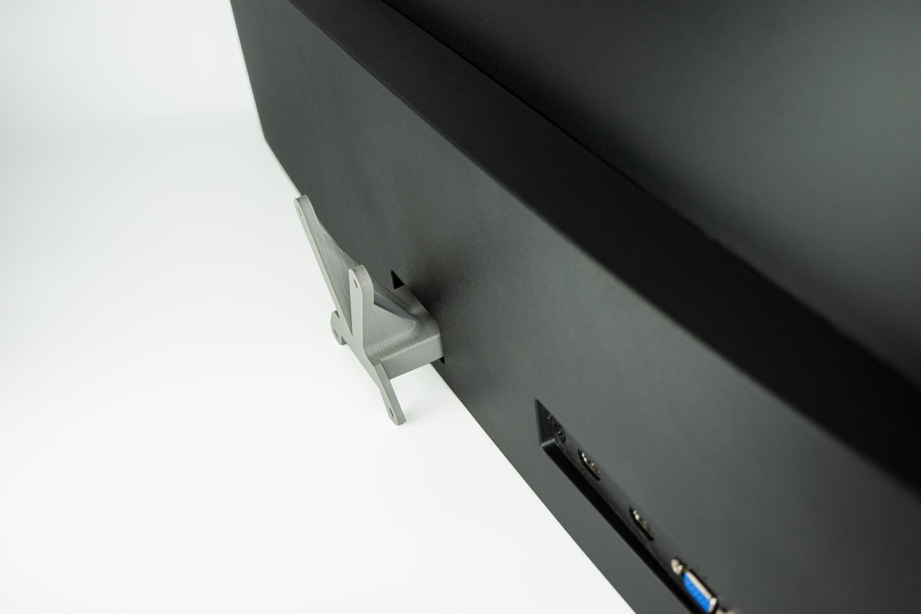 Ein schwarzer Monitor mit einer Halterung. Die Halterung ist an der Rückseite des Monitors befestigt.