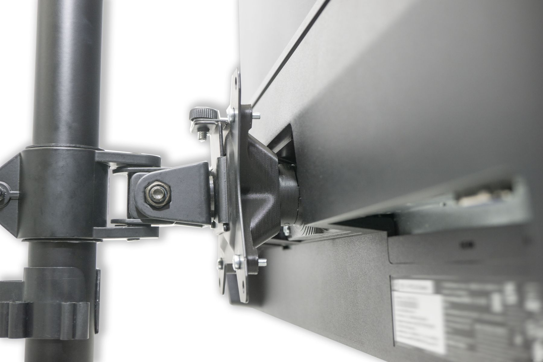 Ein Monitor ist an einem Arm montiert. Die Halterung ist schwarz und mit einer Stange verbunden.