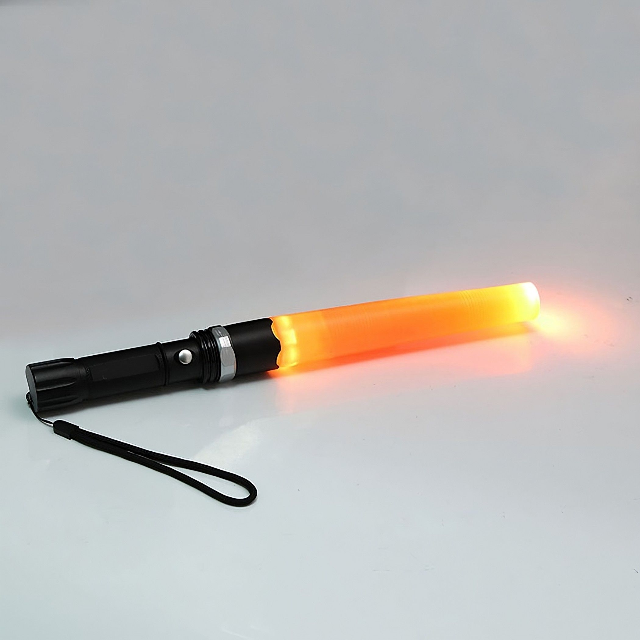 Ein schwarz-orangener Verkehrsstab, orange leuchtend, mit schwarzem Griff und Handschlaufe.