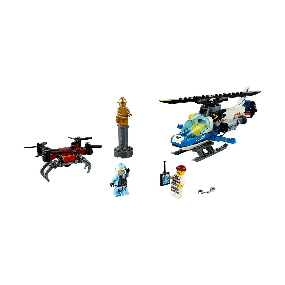 Helikopter policyjny, dron i figurki na białej powierzchni. Złoty posąg stoi na piedestale.