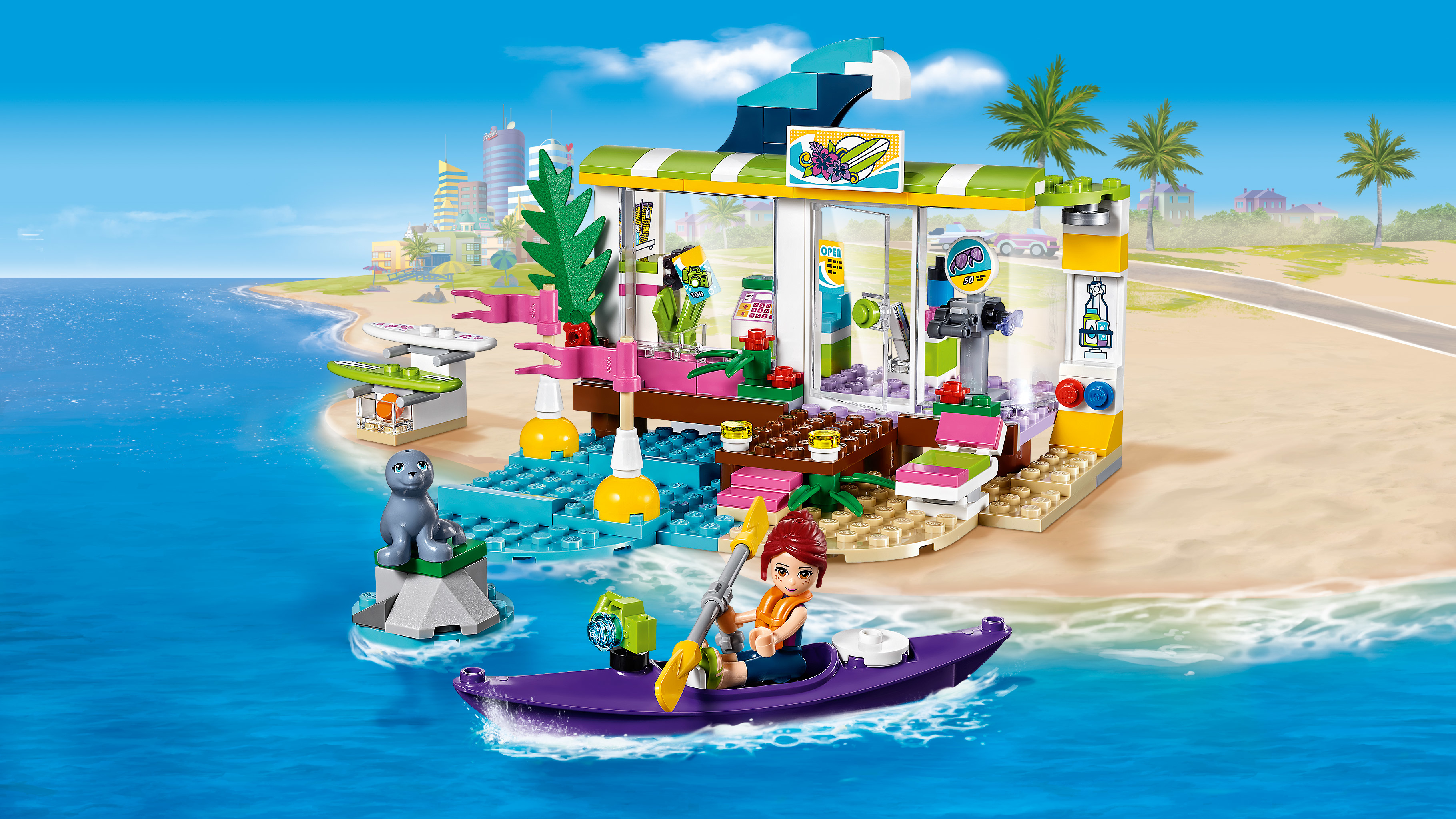 Zestaw Lego Friends z kawiarnią na plaży, kobietą pływającą kajakiem i foka. Białe tło.