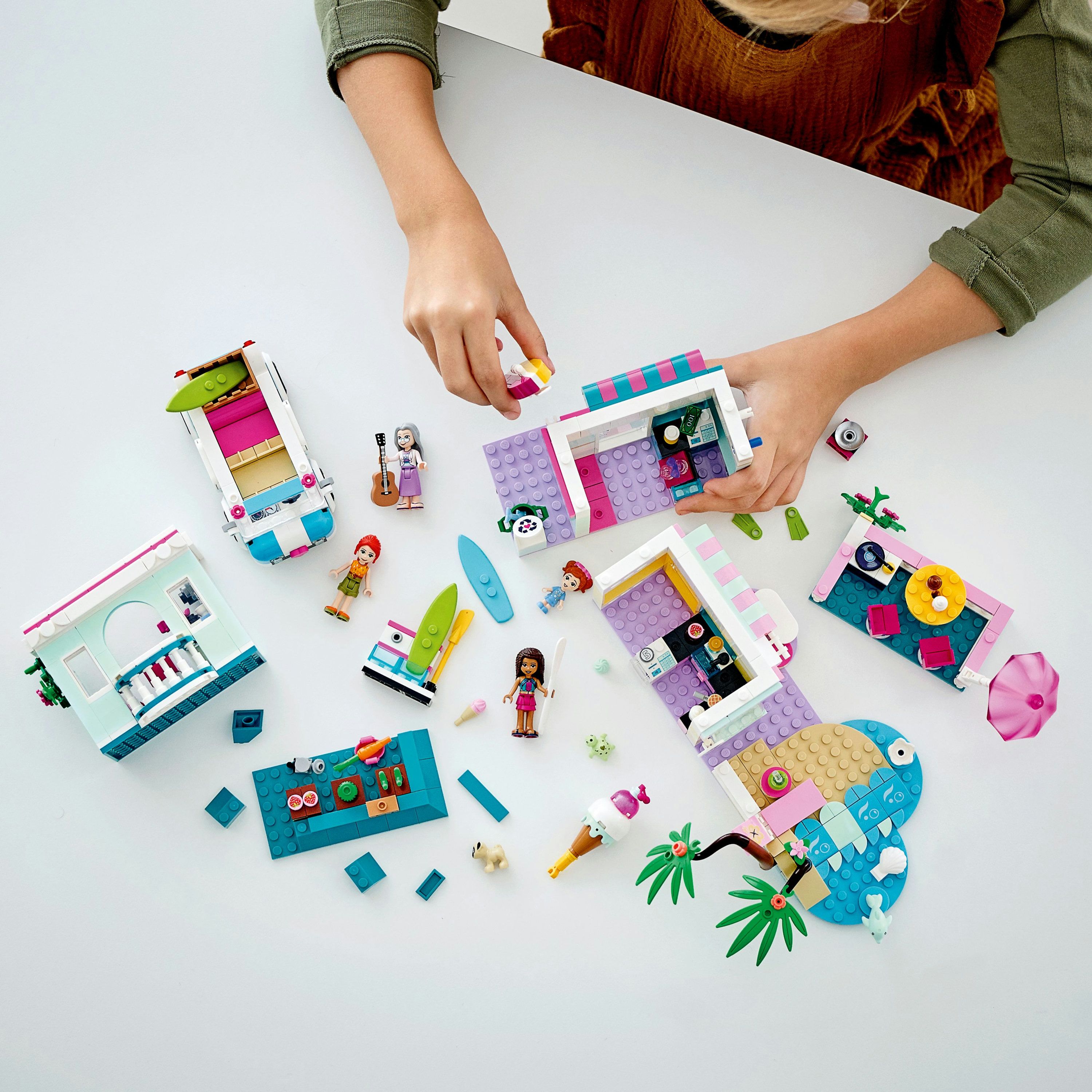 Domek na plaży Lego Friends z wieloma scenami do zbudowania i dzieckiem w interakcji.