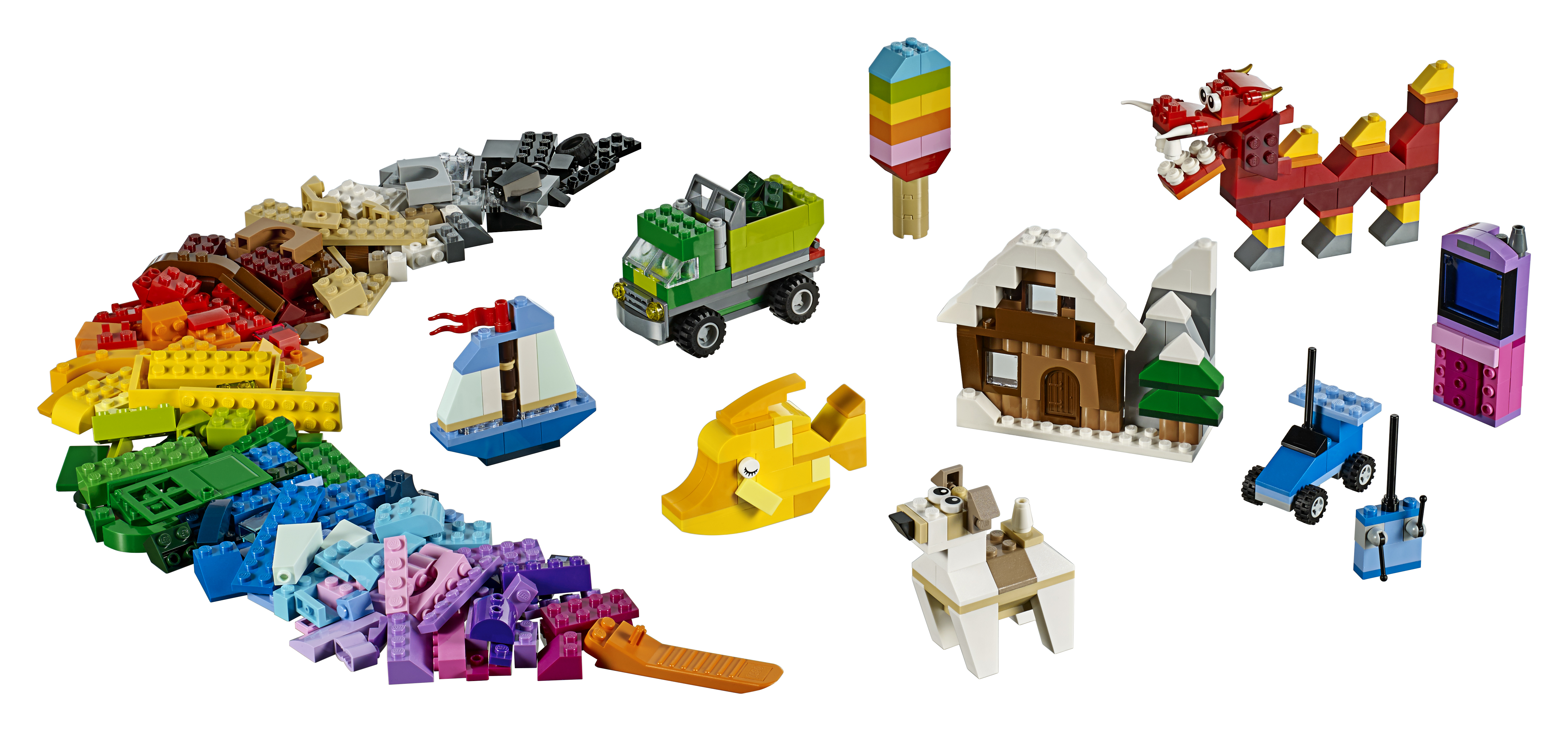 Set Lego con vari mattoncini colorati e mini-costruzioni, tra cui un pesce, un camion e un drago.
