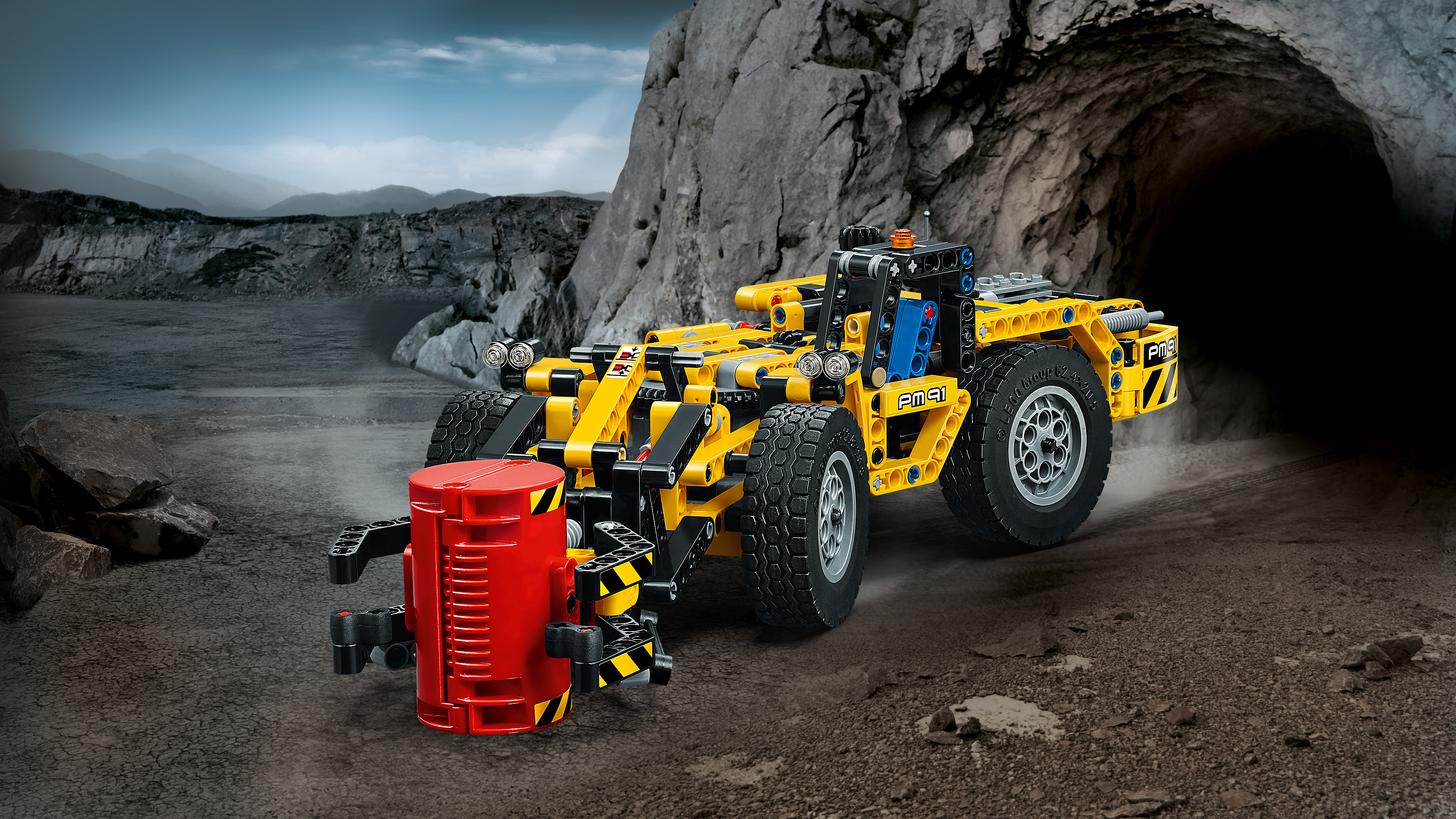 Lego Technic set met een gele bouwmachine in een rotsachtige omgeving.