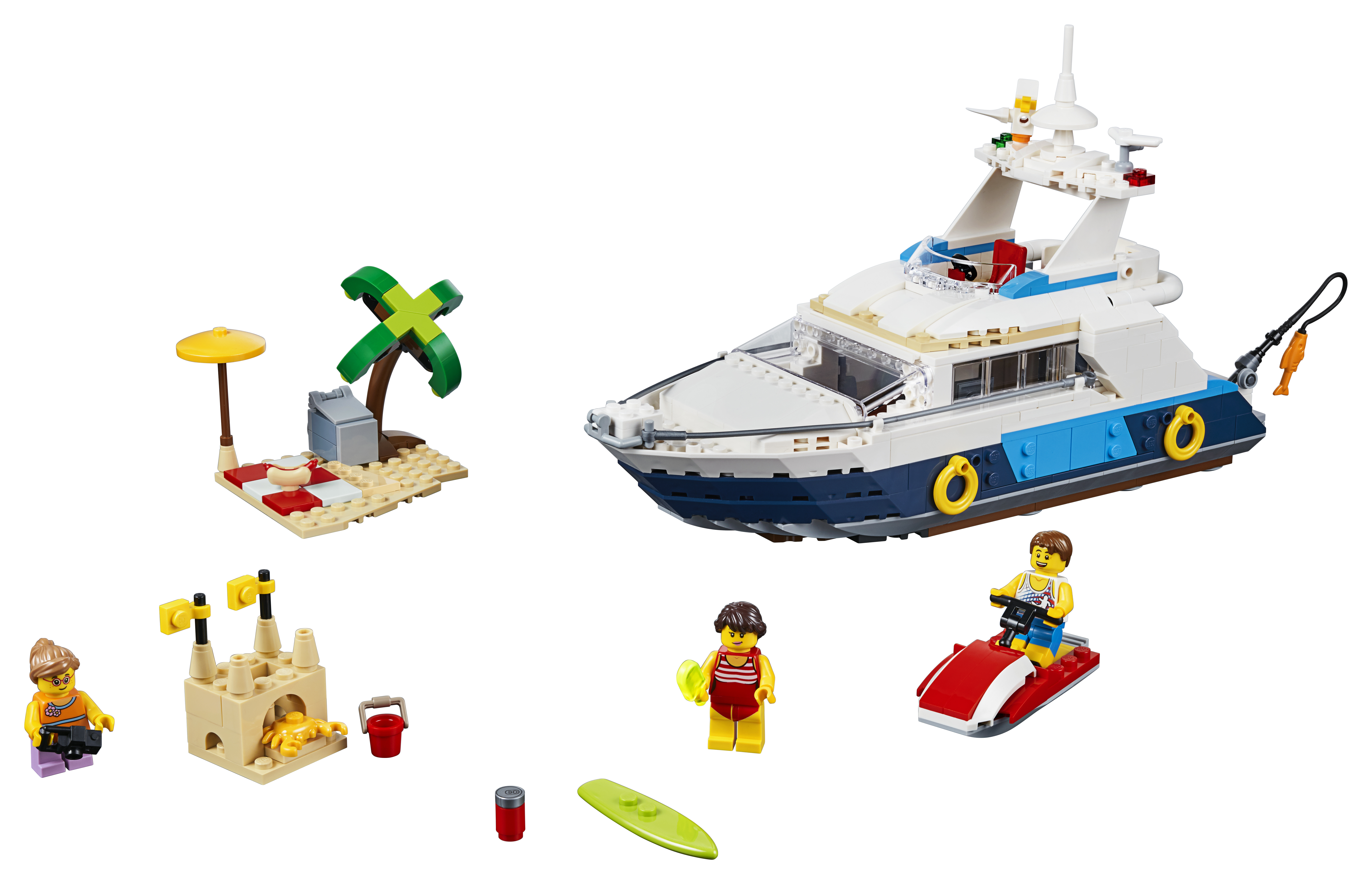 Lego set met een jacht, strandelementen en minifiguren van mensen op het strand.
