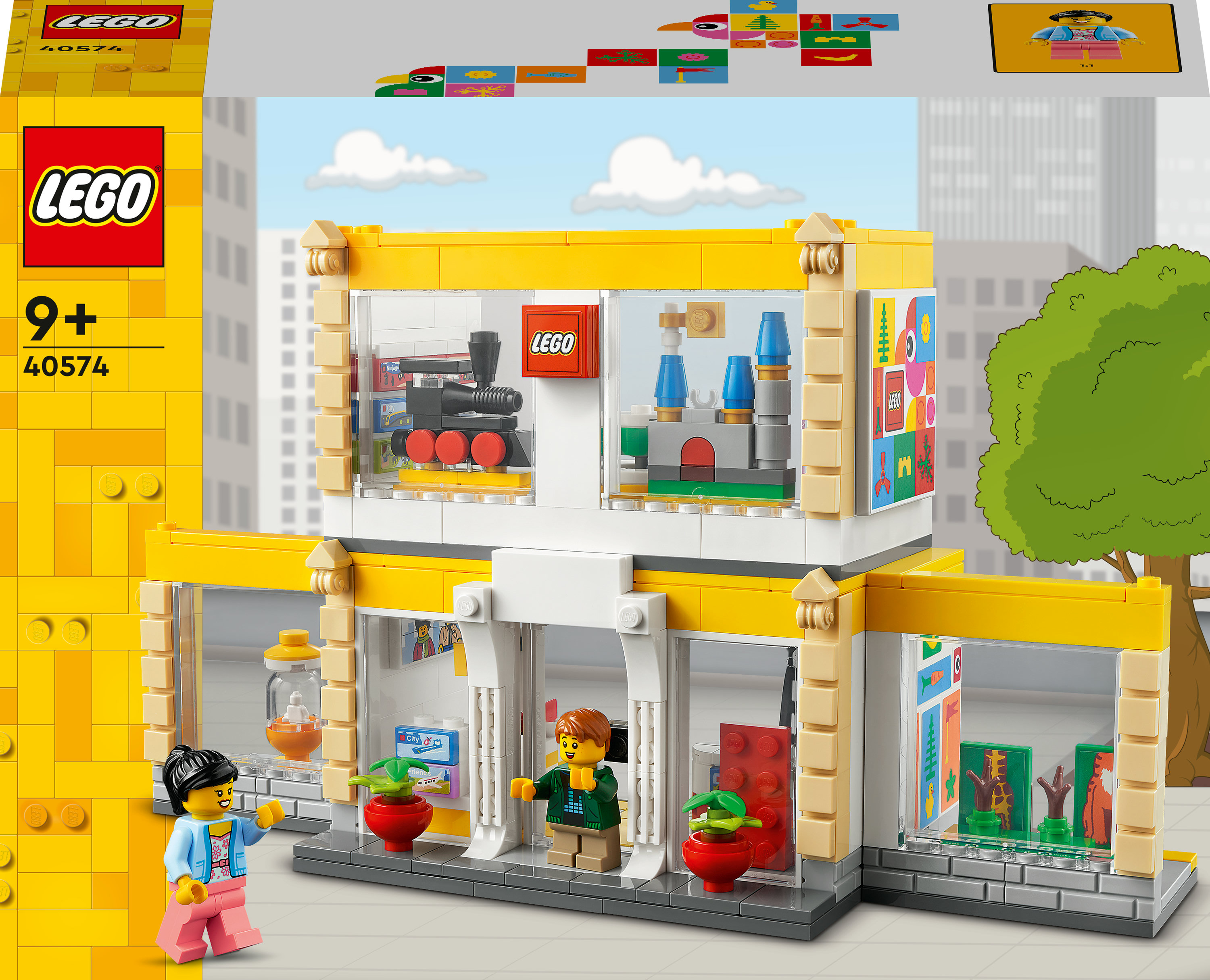 Un set Lego mostra un edificio con due minifigure. L'edificio è giallo e bianco e ha più finestre.