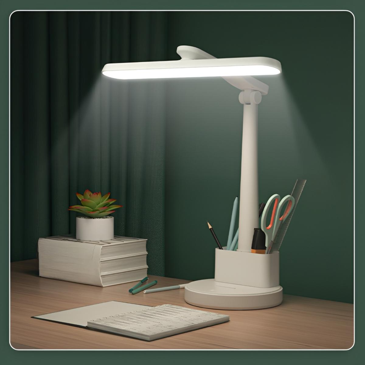 Eine weiße Schreibtischlampe beleuchtet einen Schreibtisch mit Schreibwaren und einer Pflanze. Grüner Hintergrund.