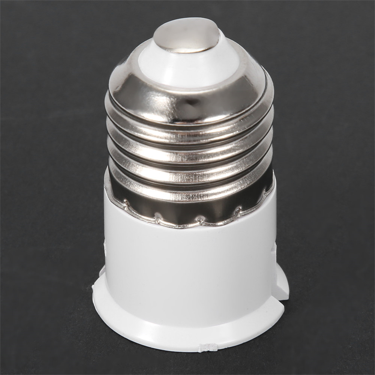 Weißer Glühbirnen-Sockeladapter. Silbernes Metalloberteil, weißer Körper. Schwarzer Hintergrund.