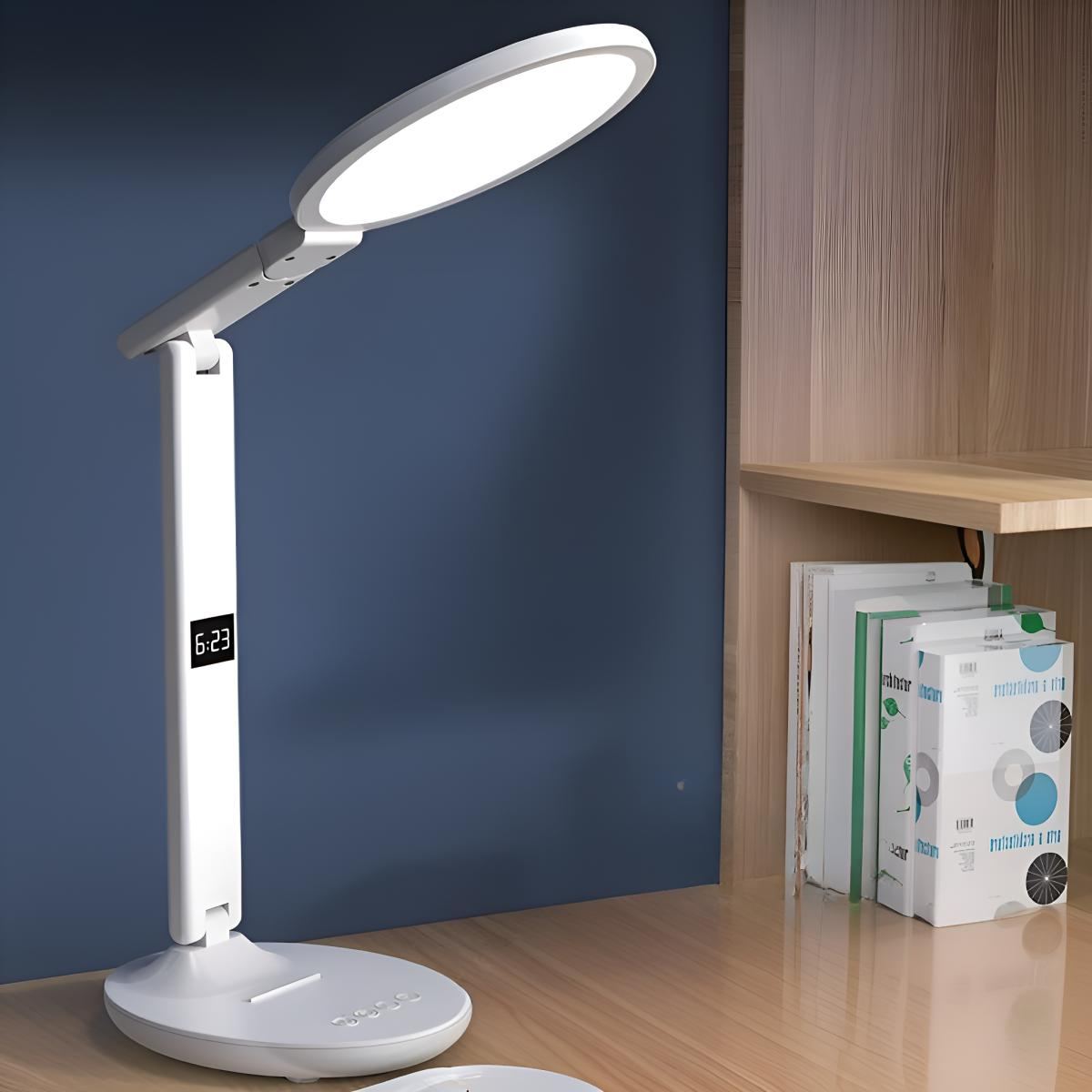 Eine weiße Schreibtischlampe mit Digitalanzeige und ein paar Büchern auf einem Schreibtisch.
