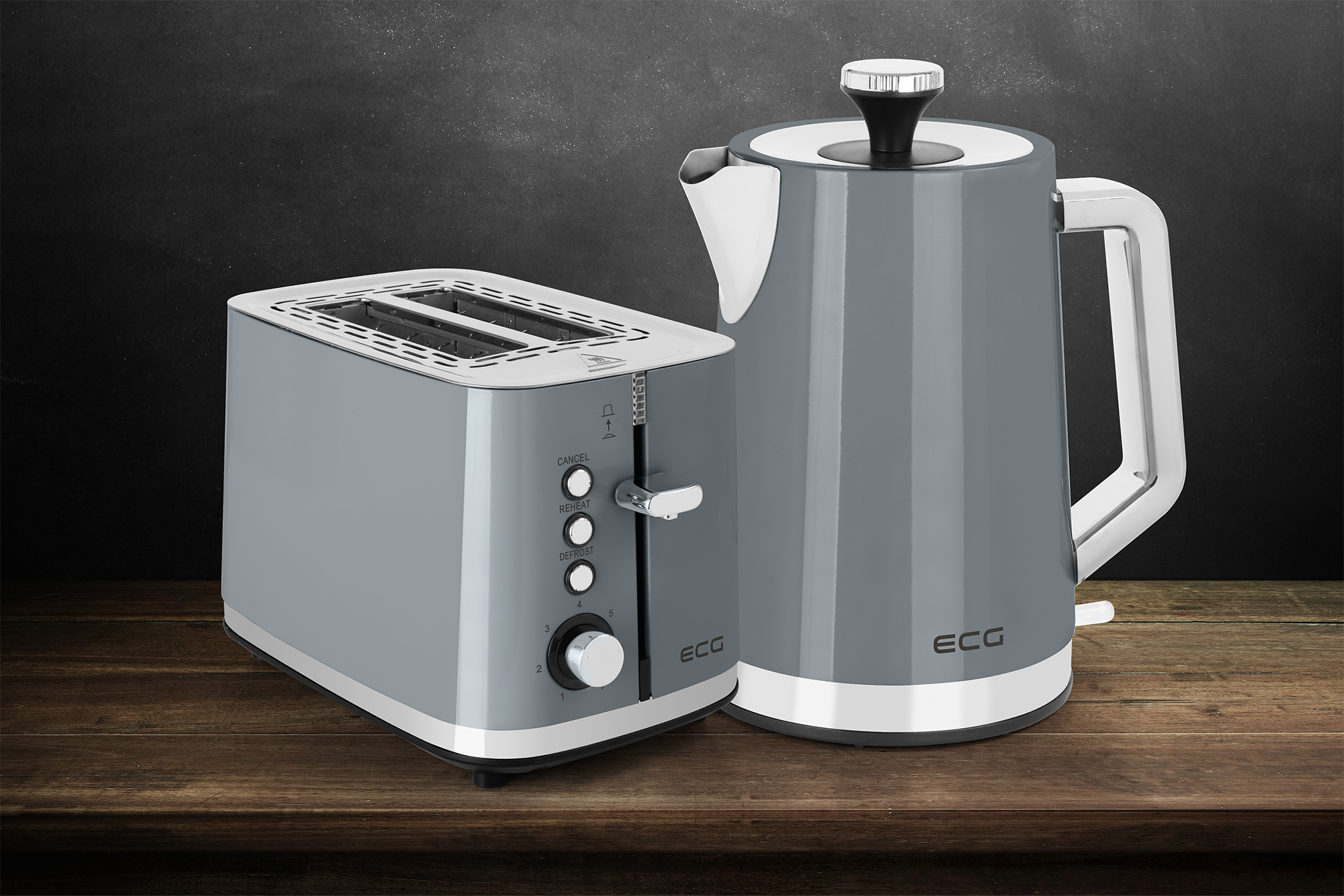 Grauer Toaster und Wasserkocher auf Holzoberfläche vor dunklem Hintergrund.
