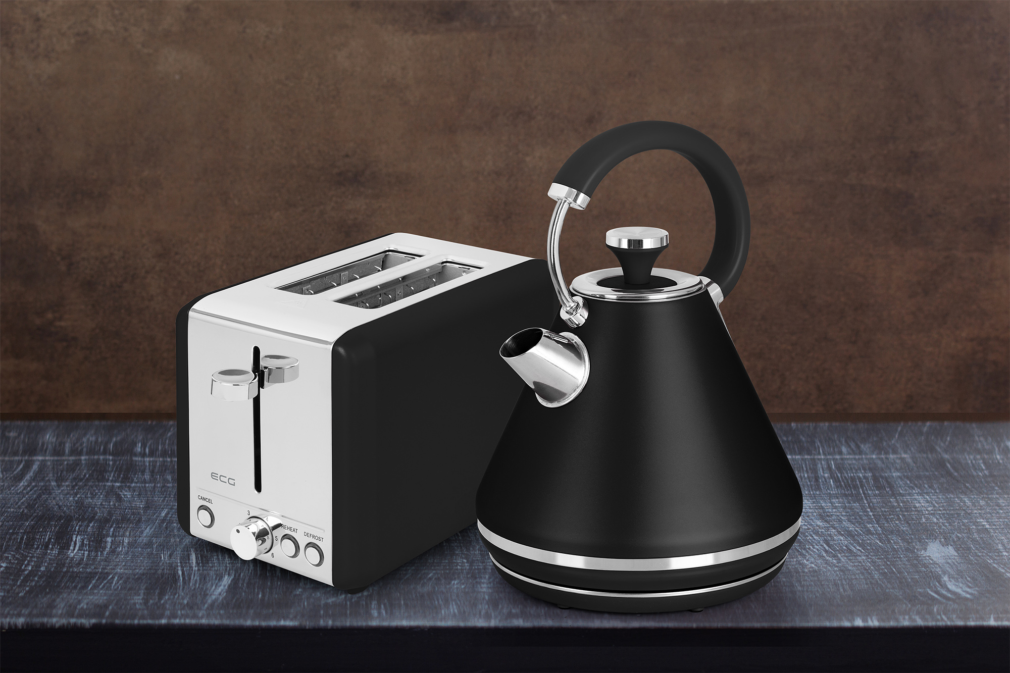 Ein schwarzer Toaster und ein schwarzer Wasserkocher auf einem blauen Tisch. Der Hintergrund ist eine braune Wand.
