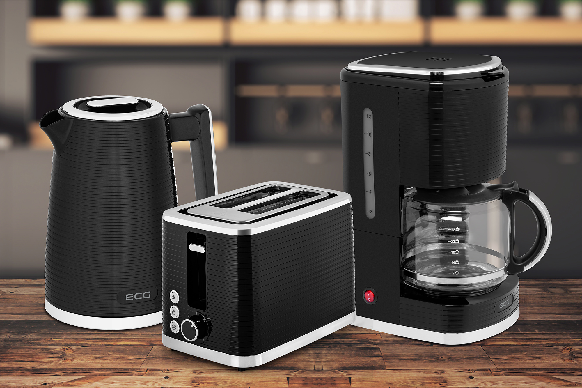 Czarny czajnik, toster i ekspres do kawy na drewnianym tle.