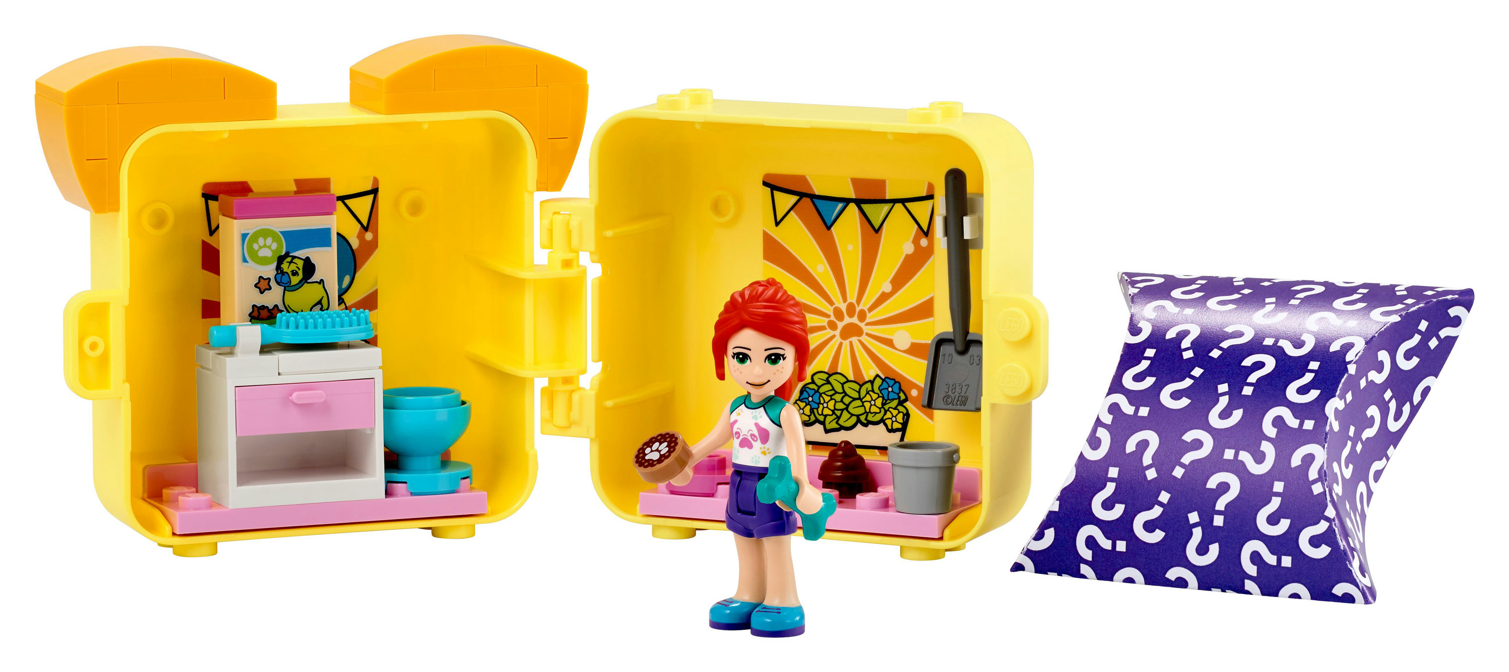 Set LEGO Friends. Una scatola gialla con un playset a tema animali domestici e una figurina di ragazza.