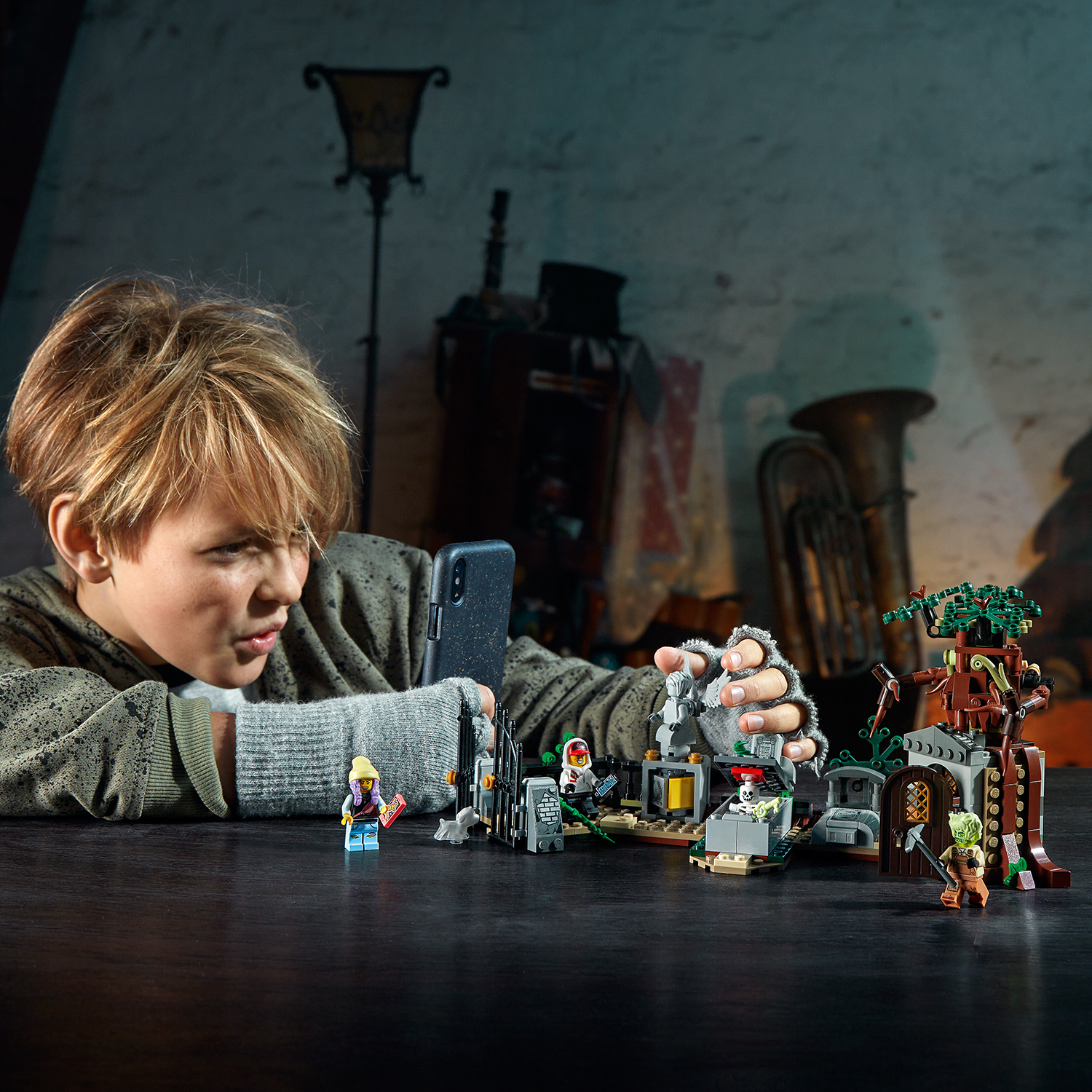 Un ragazzo che gioca con un set LEGO, con uno sfondo scuro con strumenti musicali.