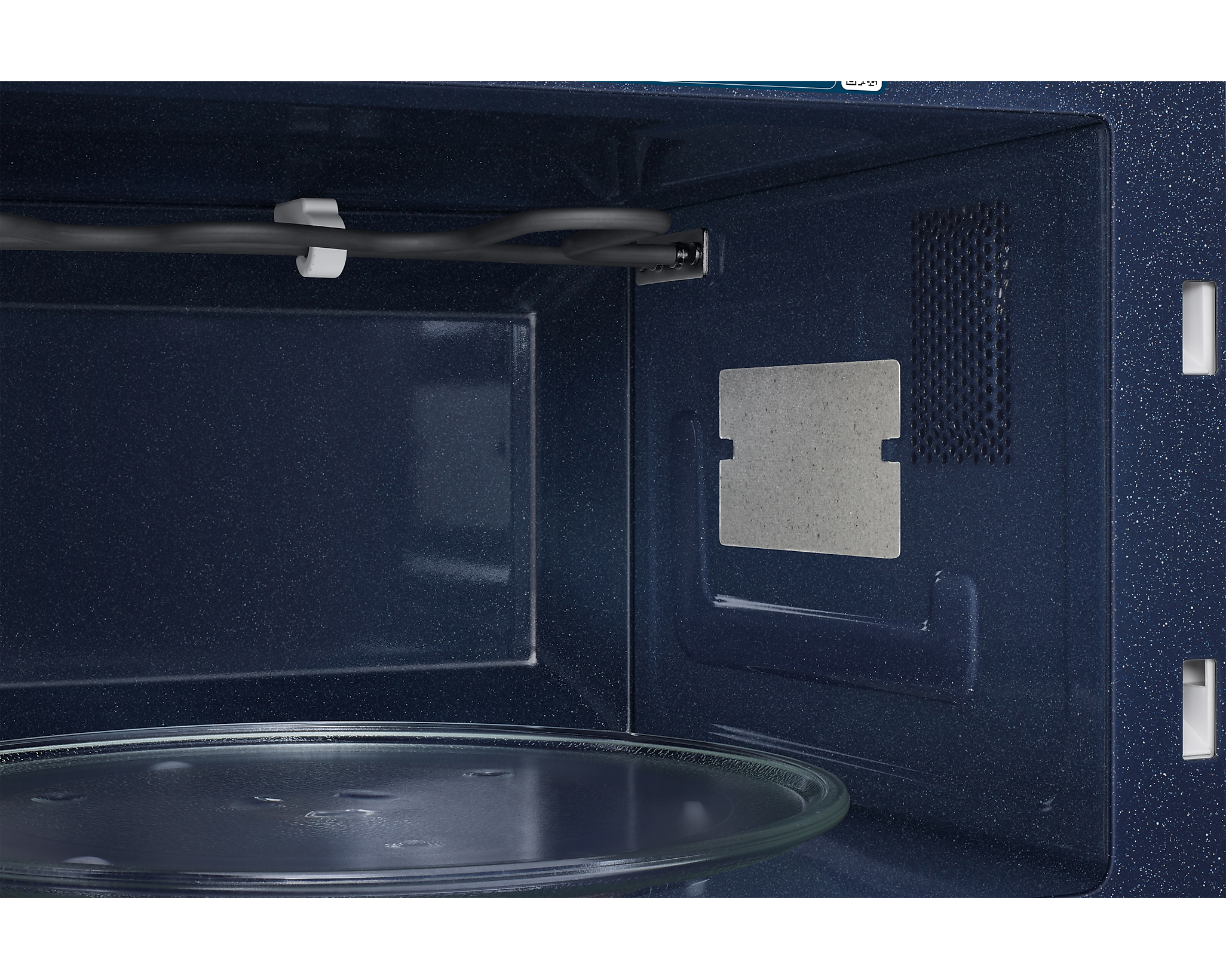 Vista interna di un microonde blu con piatto in vetro ed elemento riscaldante.
