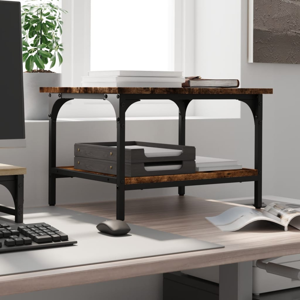 Holz- und schwarzer Metallschreibtisch mit Büchern, Papierkörben und einer Tastatur. Im Hintergrund befinden sich ein Fenster und eine Pflanze.