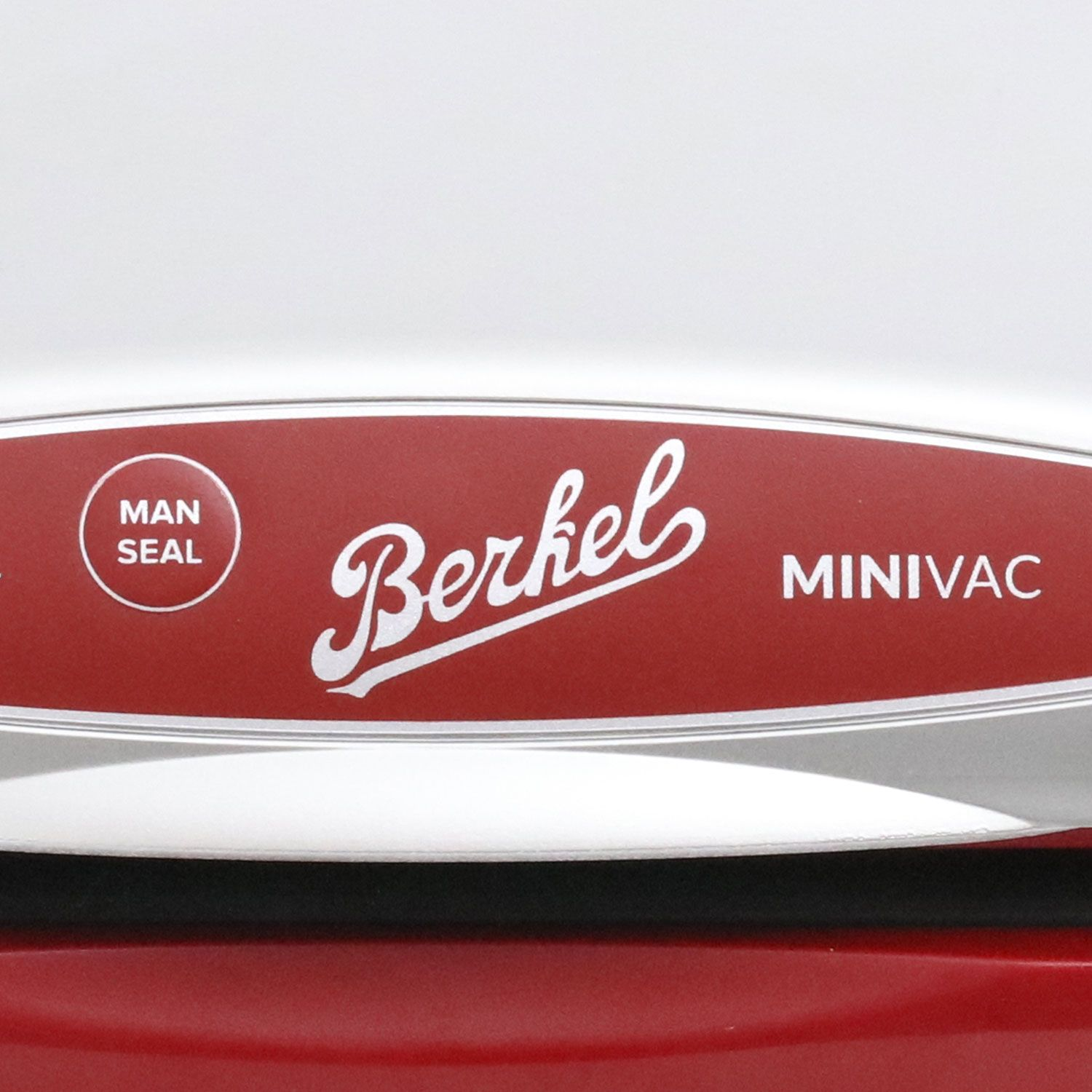 Un Berkel MINIVAC rosso e argento, con la scritta 'MAN SEAL' a sinistra.