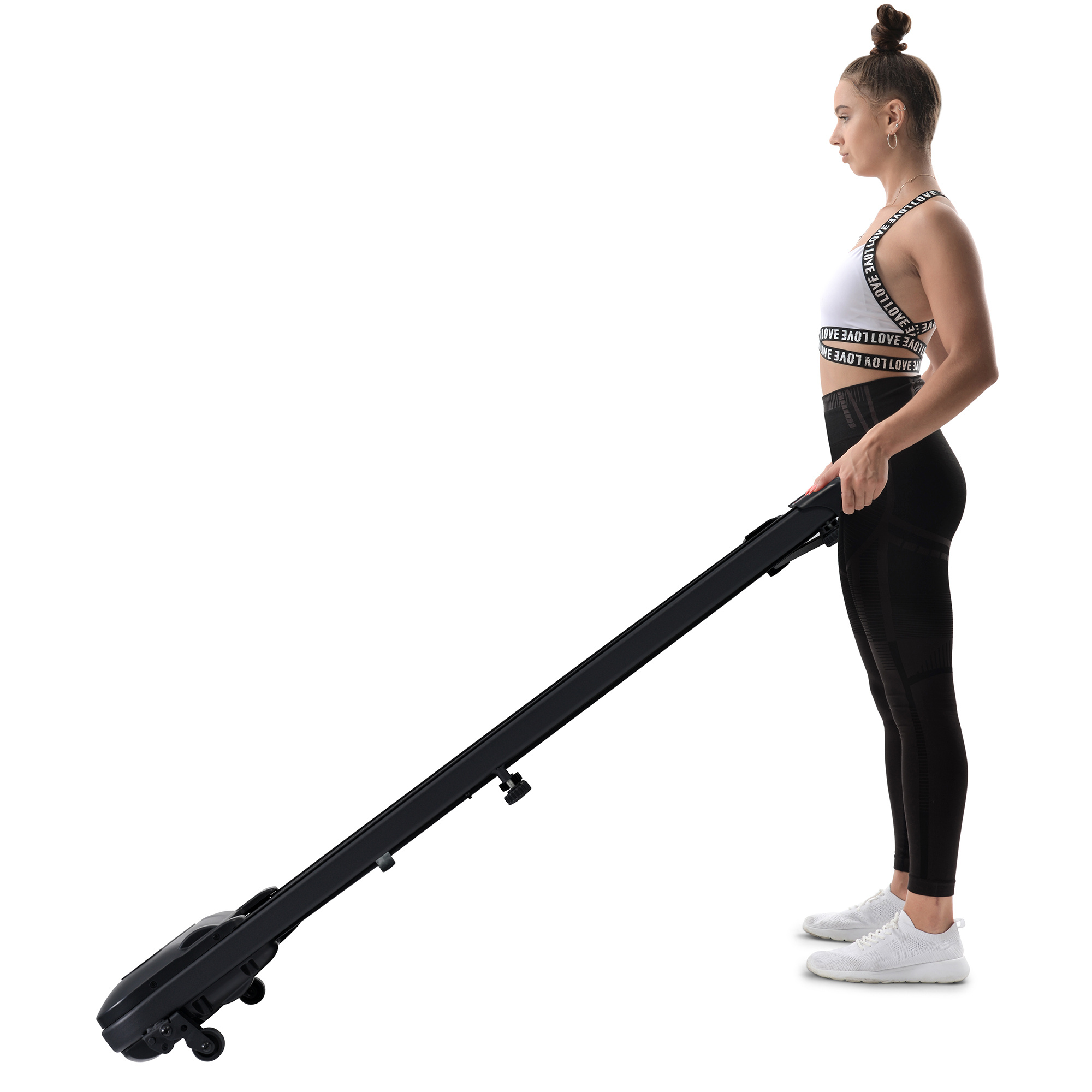 Eine Frau steht mit einem schwarzen, zusammenklappbaren Laufband vor weißem Hintergrund in einem Fitnessstudio.