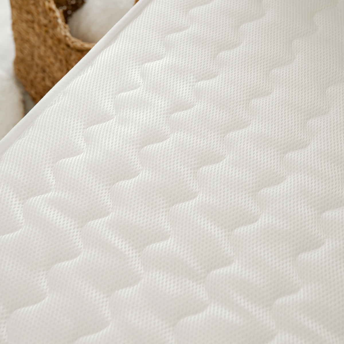 Primer plano de una superficie de colchón blanco con un patrón de diamantes. Muestra la textura y el tejido de la tela.