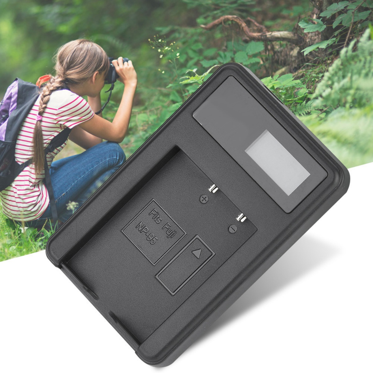 Frau mit Kamera macht Fotos in der Natur. Ein schwarzes Ladegerät ist im Vordergrund.