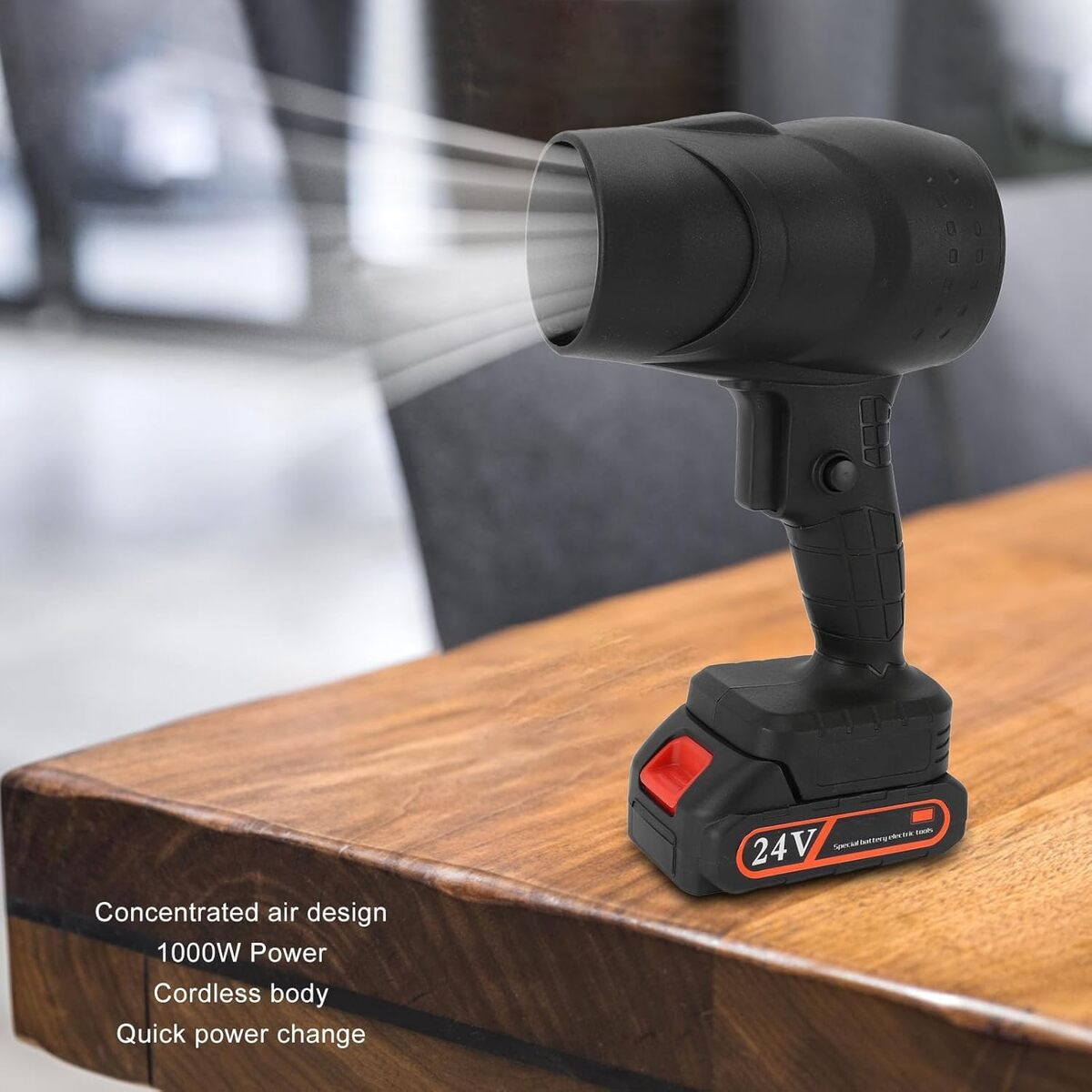 Foco inalámbrico negro sobre una mesa de madera, con batería roja.