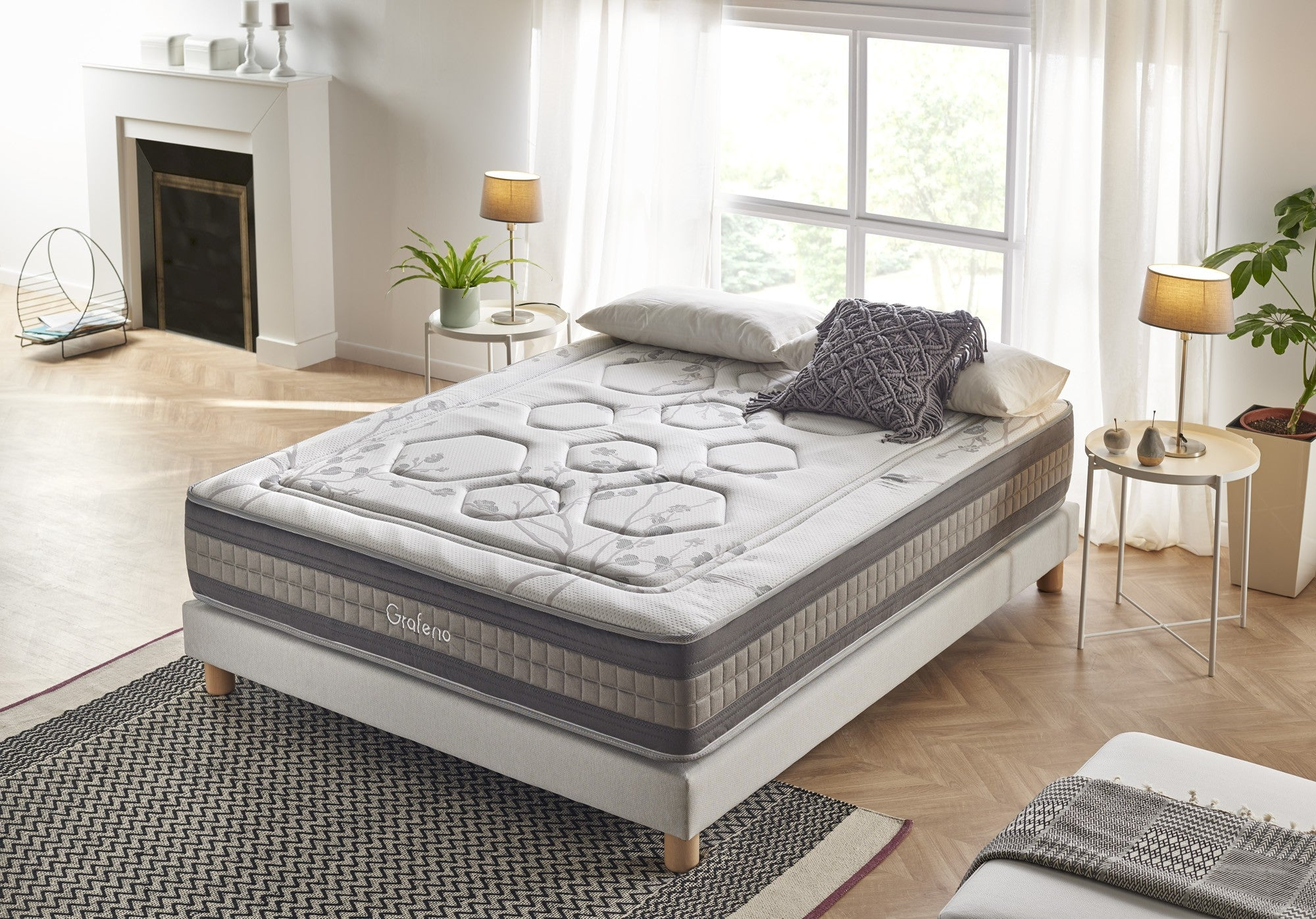 Dormitorio con cama, almohadas, mesitas y ventana. Una alfombra está en el suelo.