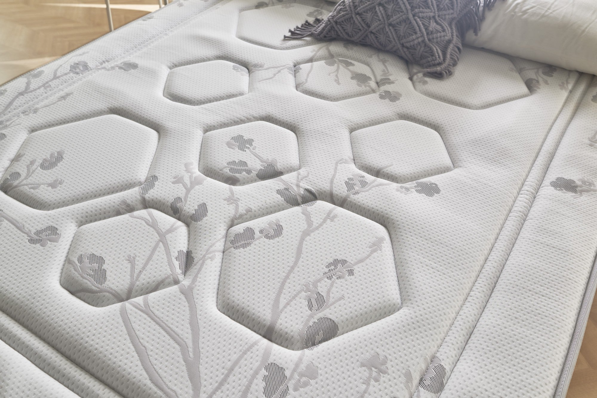 Primer plano de un colchón con diseño floral y formas hexagonales.