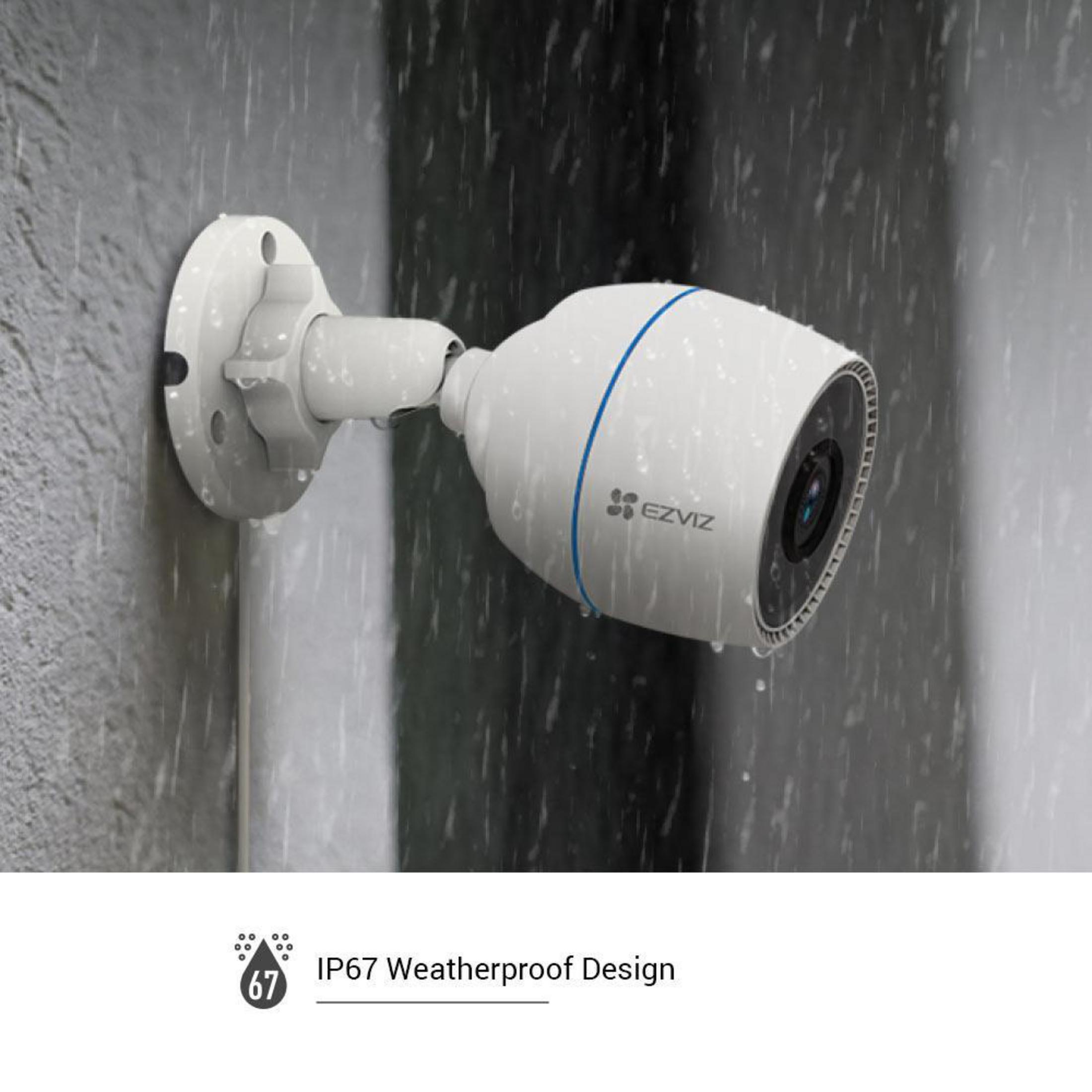 Una telecamera di sicurezza bianca su un muro. La pioggia cade sulla telecamera. Le parole IP67 Waterproof Design sono visibili.
