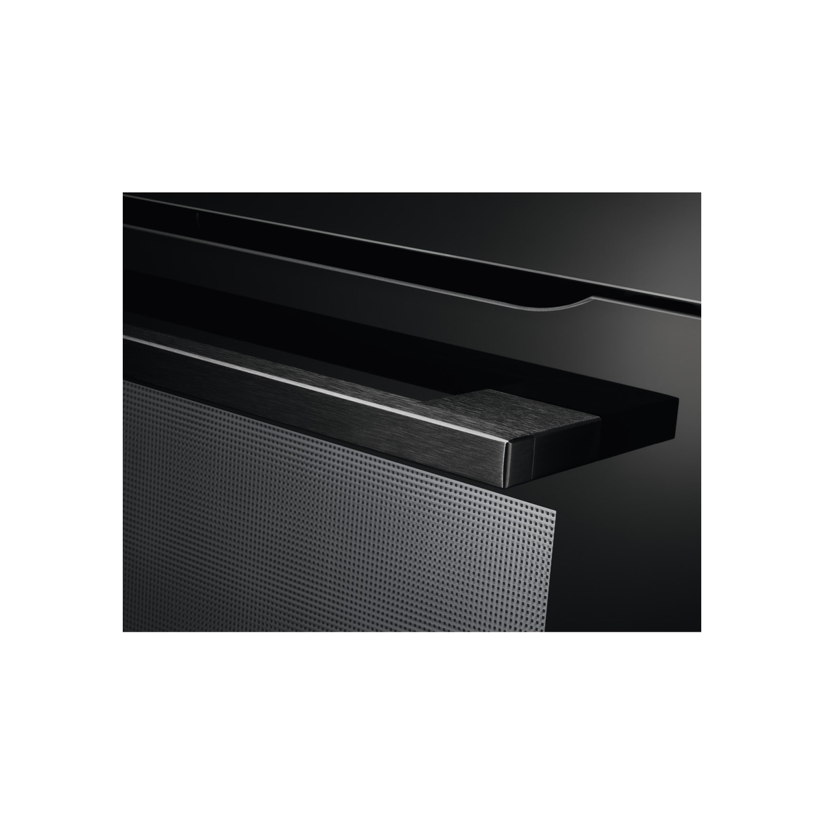 Dettaglio del forno nero, che mostra un interno scuro con un pannello metallico perforato.
