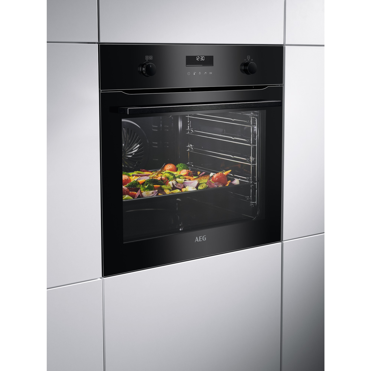 Un forno nero a incasso con display e un vassoio di verdure all'interno.