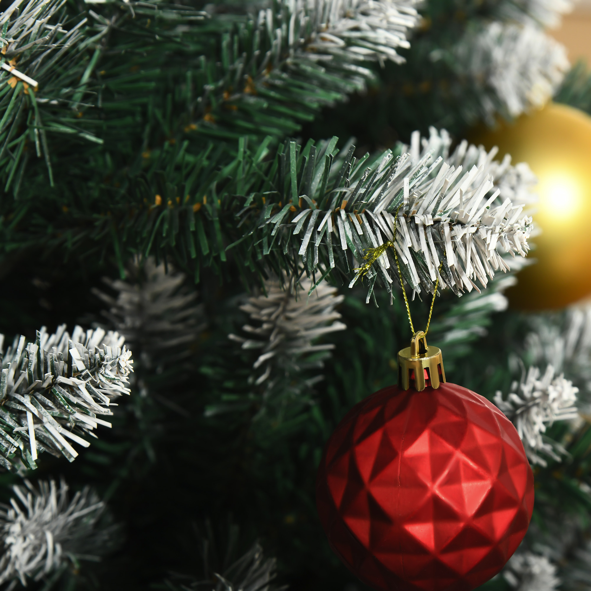 Primer plano de un árbol de Navidad con adornos rojos y dorados.