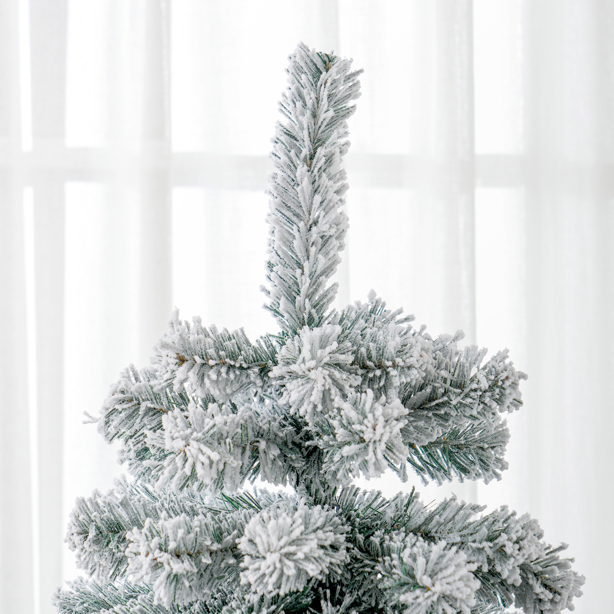 Primer plano de la parte superior de un árbol de Navidad nevado, mostrando ramas escarchadas.