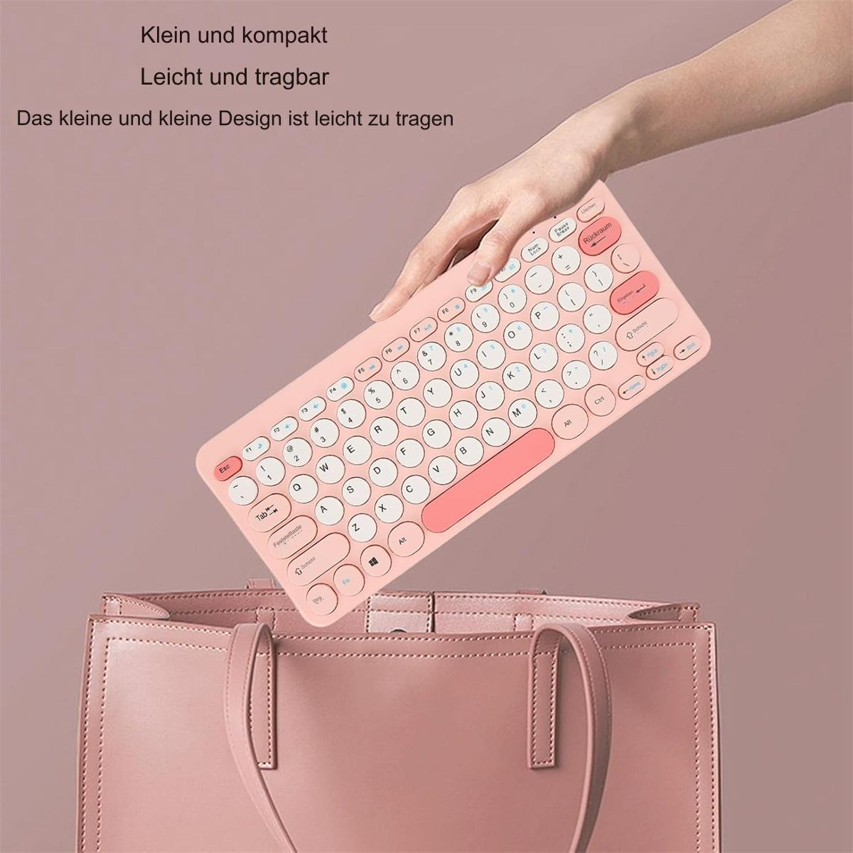 Eine Hand legt eine rosa Tastatur in eine rosa Handtasche. Weiße Tasten mit rosa Rahmen.