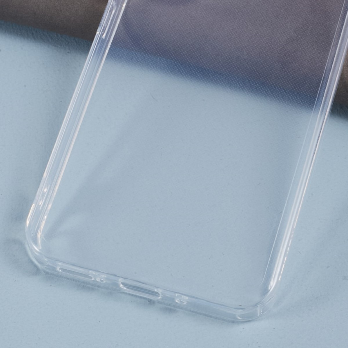 Eine transparente Handyhülle, rechteckige Form mit dezentem blau-grauem Hintergrund.