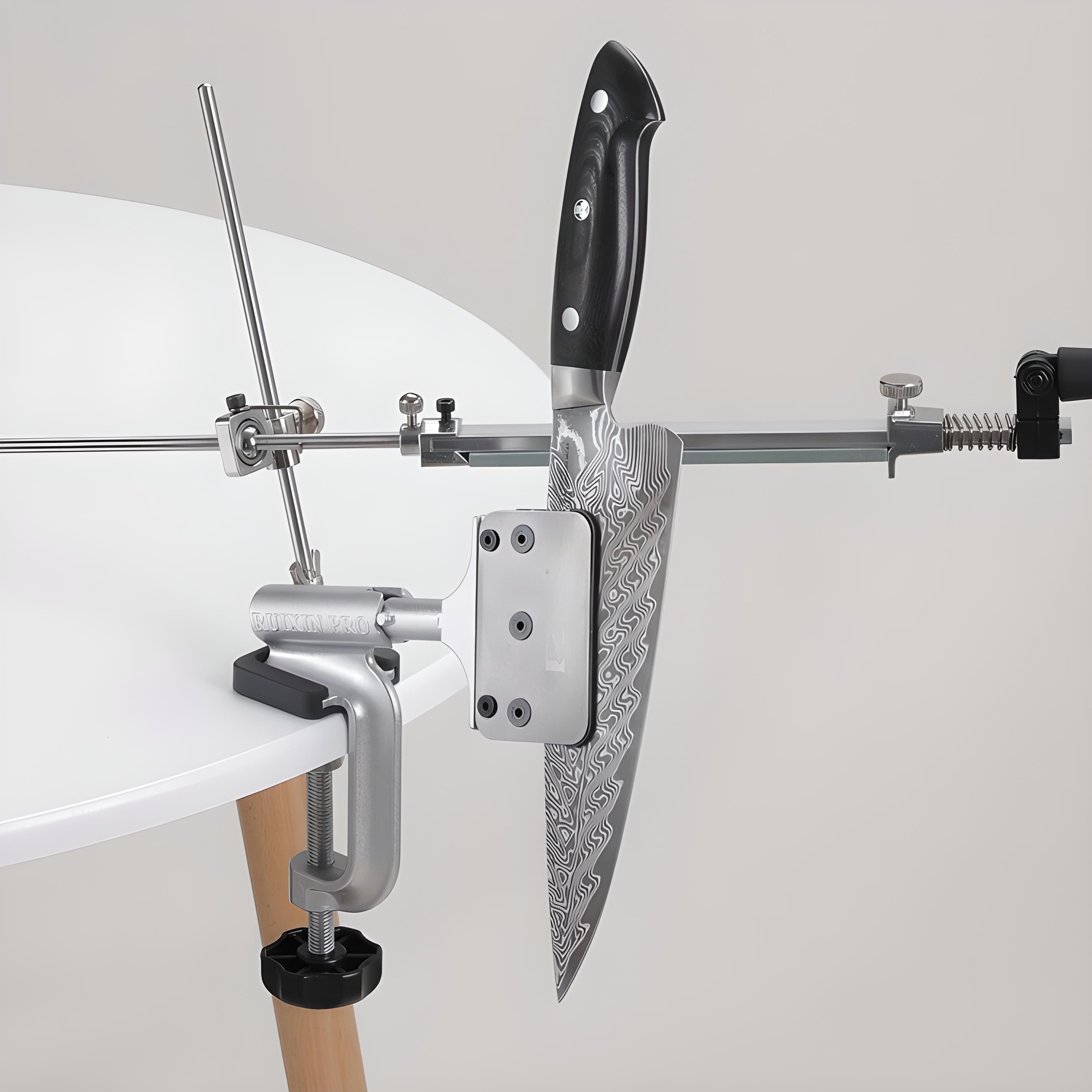 Messerschärfsystem mit Messer. Das Messer liegt auf einer Klemme. Das System steht auf einer weißen Oberfläche.