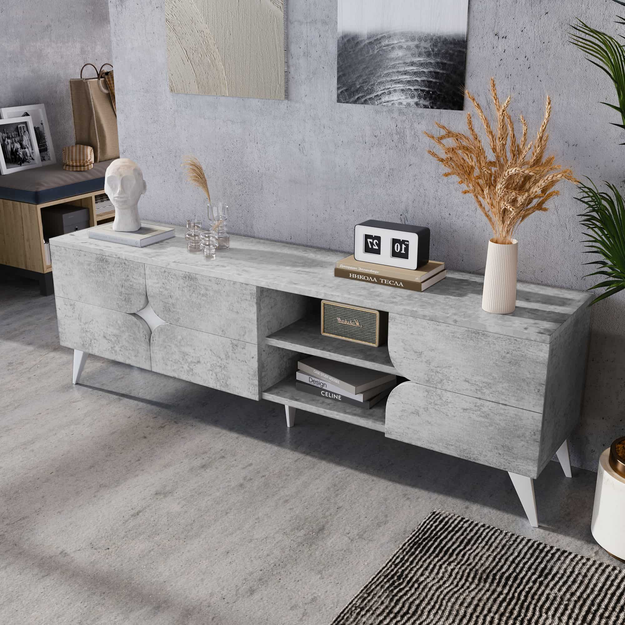 Ein grauer TV-Ständer im Beton-Stil mit weißen Beinen. Es gibt Dekorationen auf den oberen und unteren Regalen.