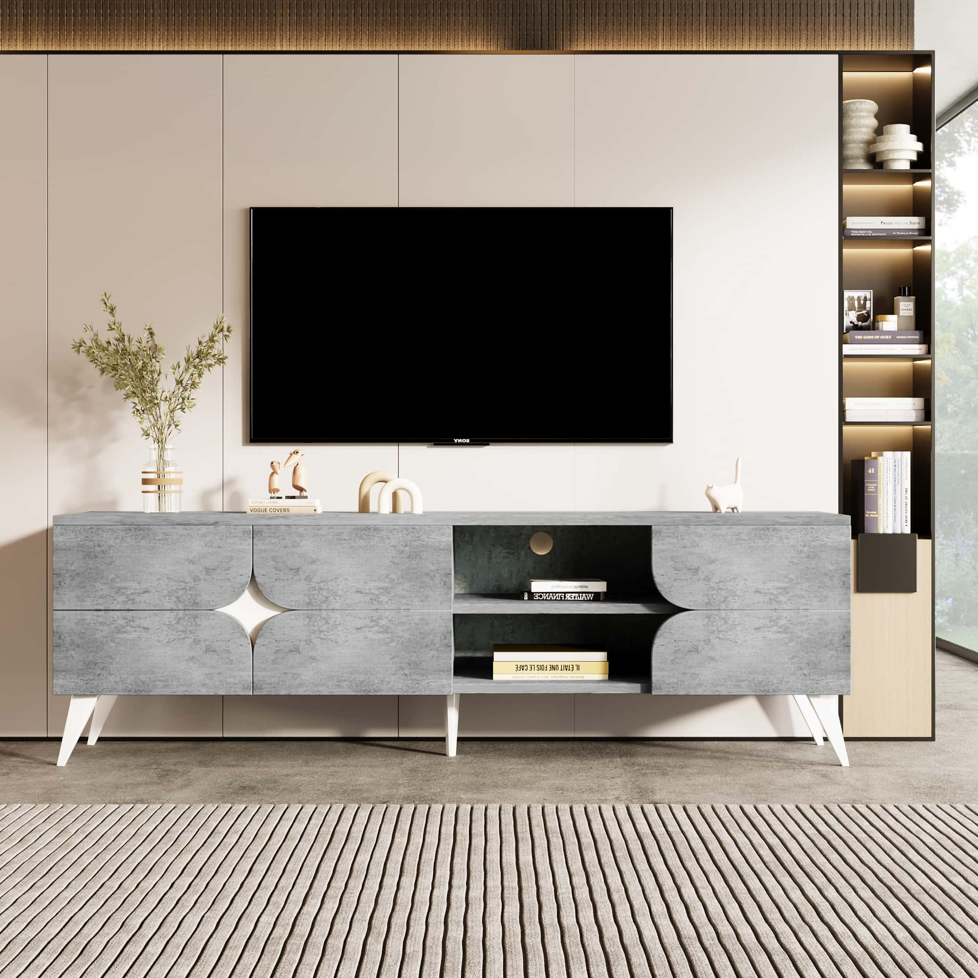 Ein grauer, moderner TV-Ständer mit Fernseher, Teppich und Dekoelementen.