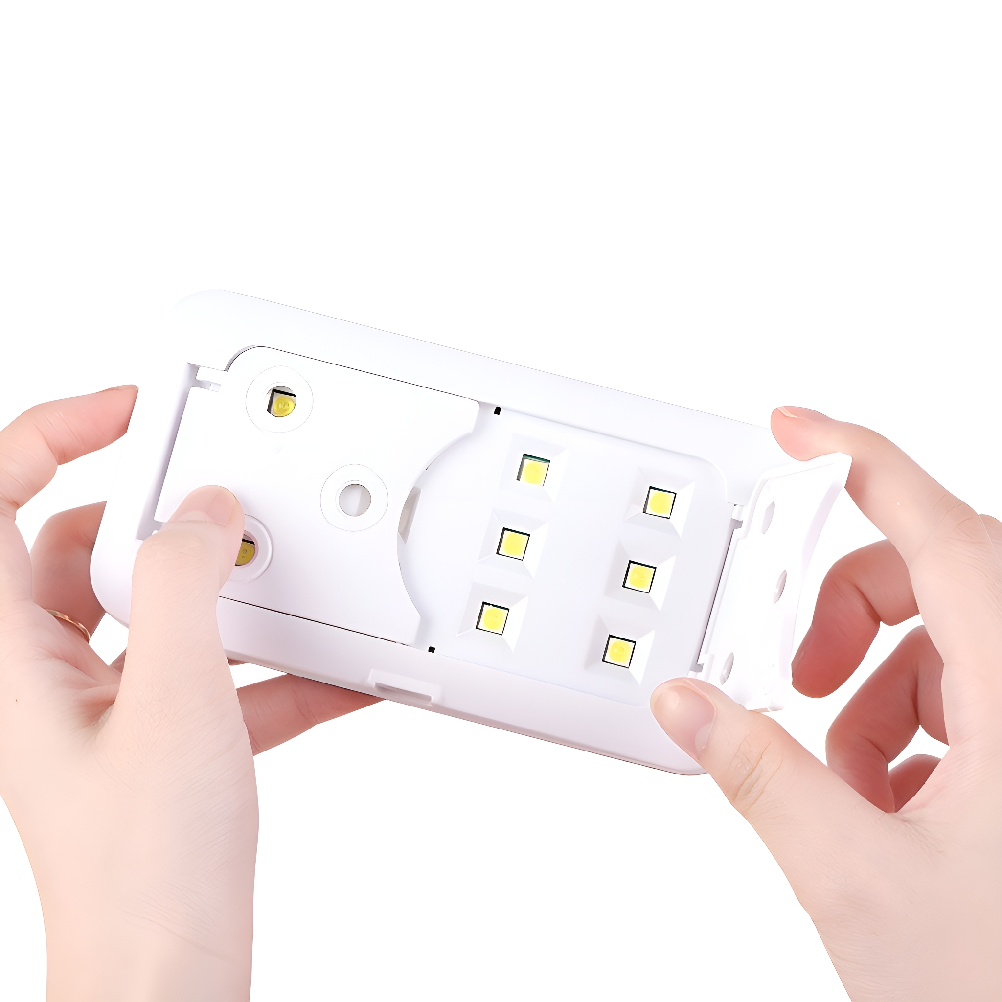 Hände halten ein weißes, offenes UV-Lichtgerät mit LEDs im Inneren.