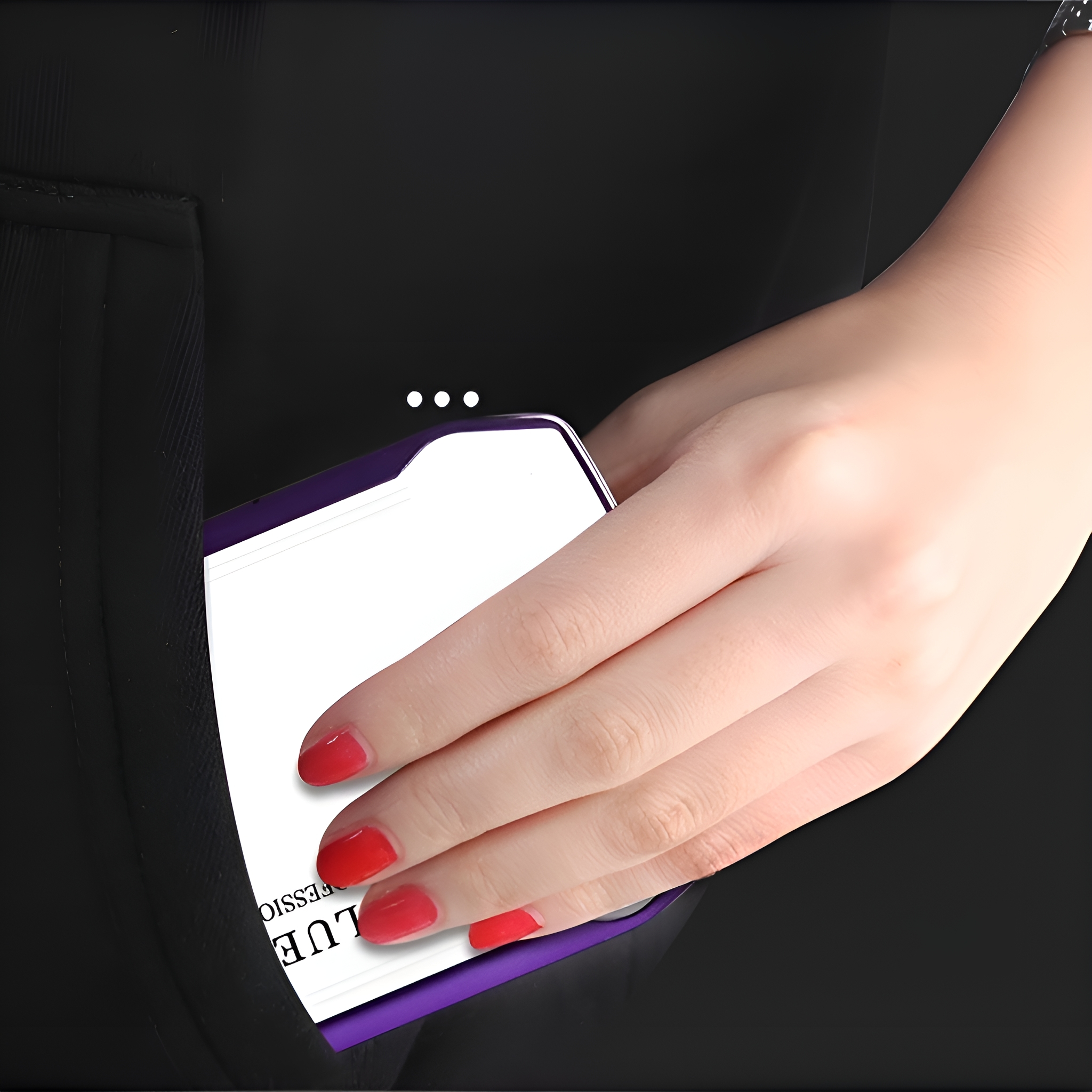 Eine Hand, die eine lila Karte in einer Tasche hält. Roter Nagellack ist sichtbar.