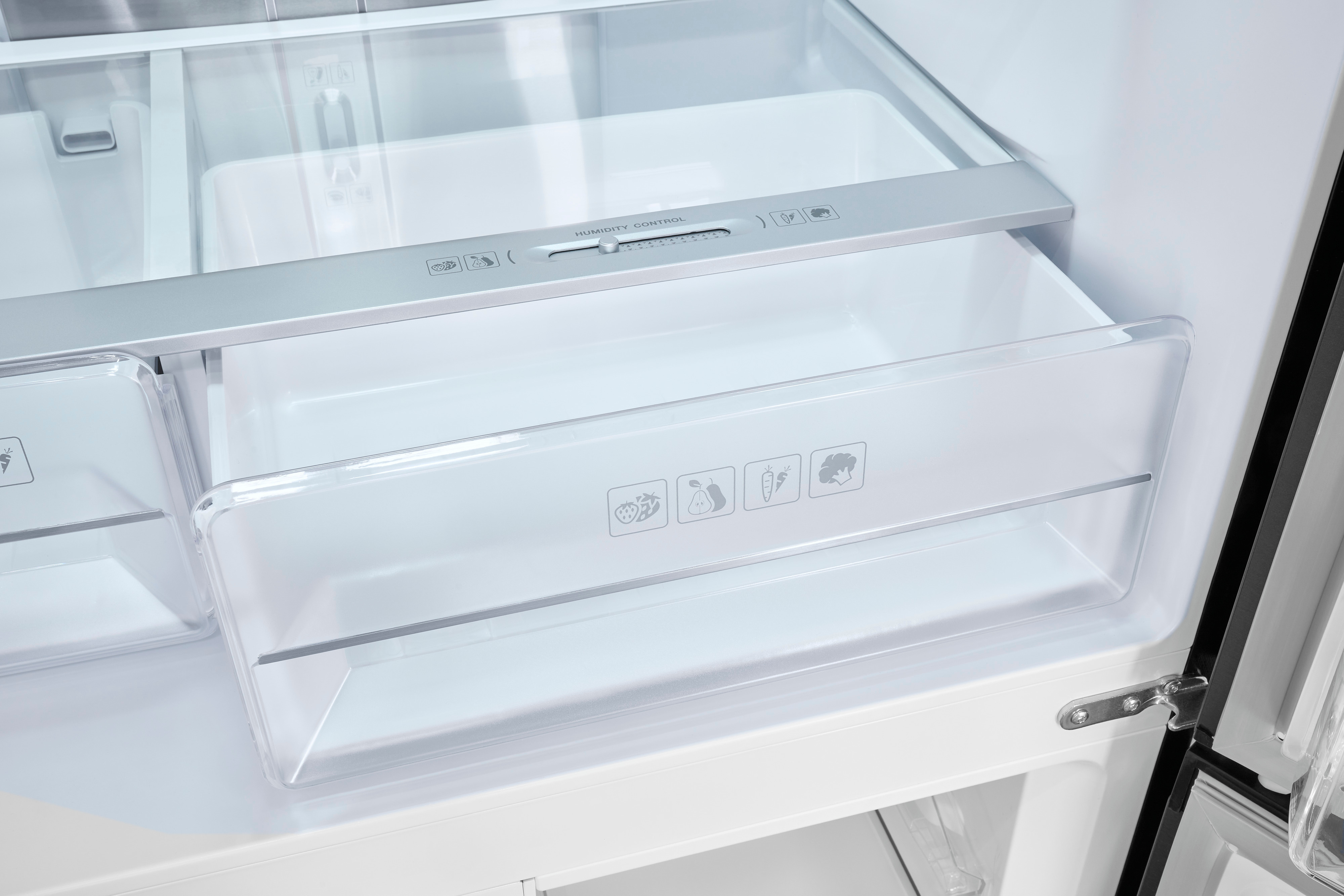 Interior de un refrigerador con cajones. Los cajones tienen etiquetas: verduras, frutas y otros iconos.
