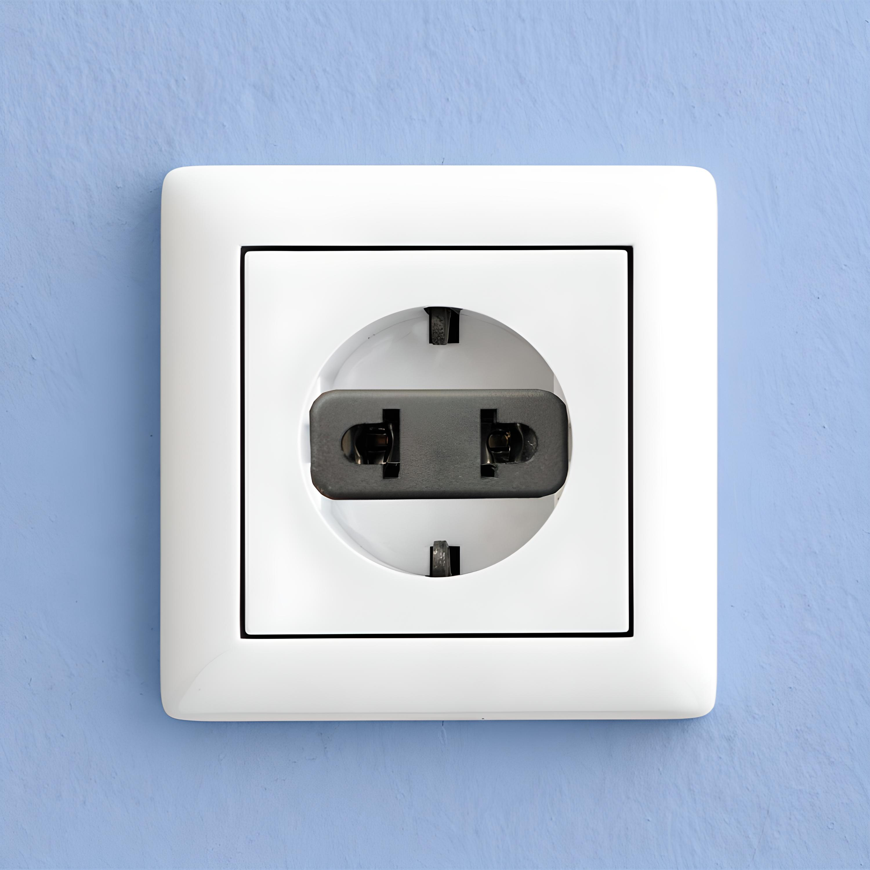 Weiße Steckdose an blauer Wand, mit eingestecktem schwarzen Stecker. Quadratische Form.