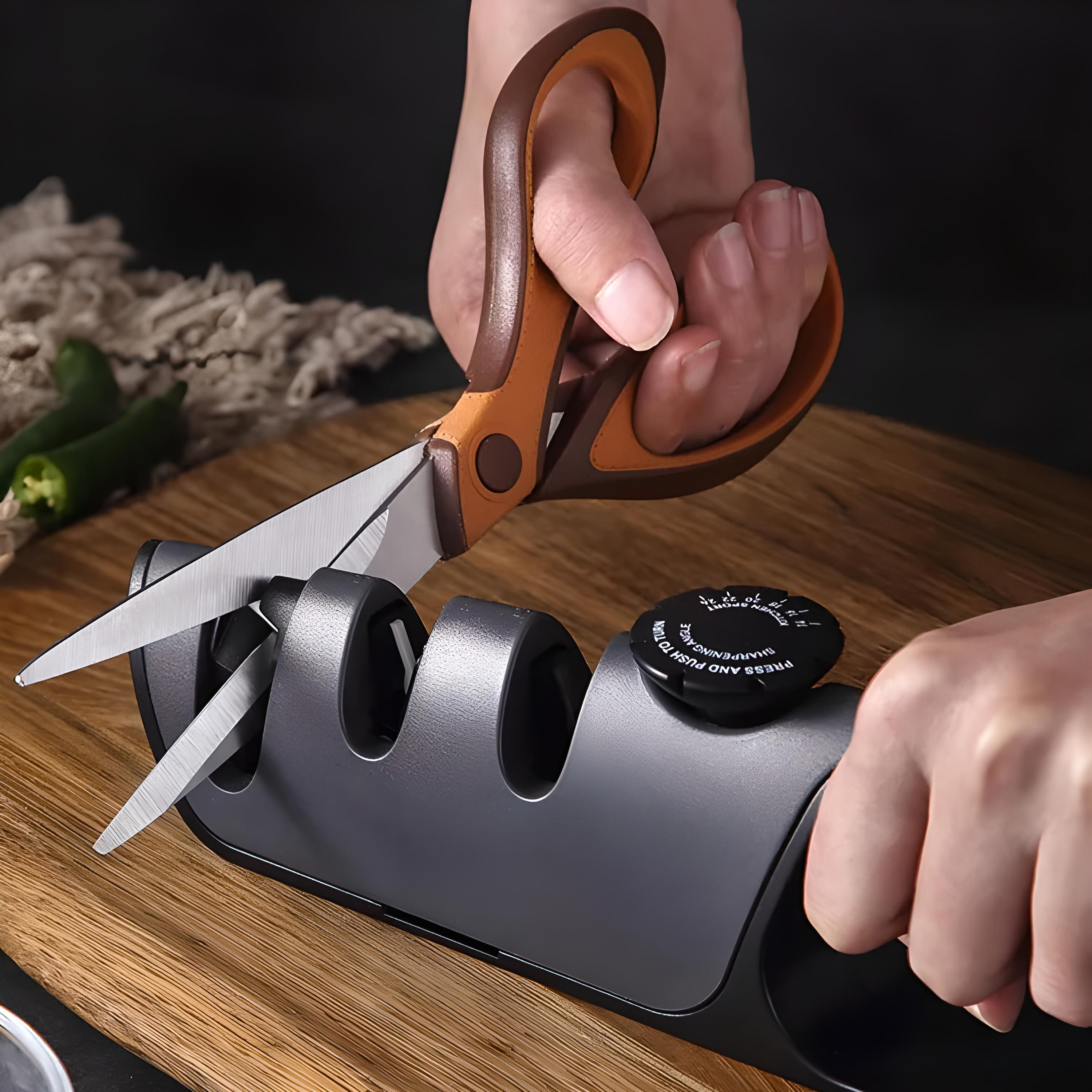 Eine Person, die eine Schere mit einem Werkzeug auf einem Holzbrett schärft, mit grünen Paprika im Hintergrund.