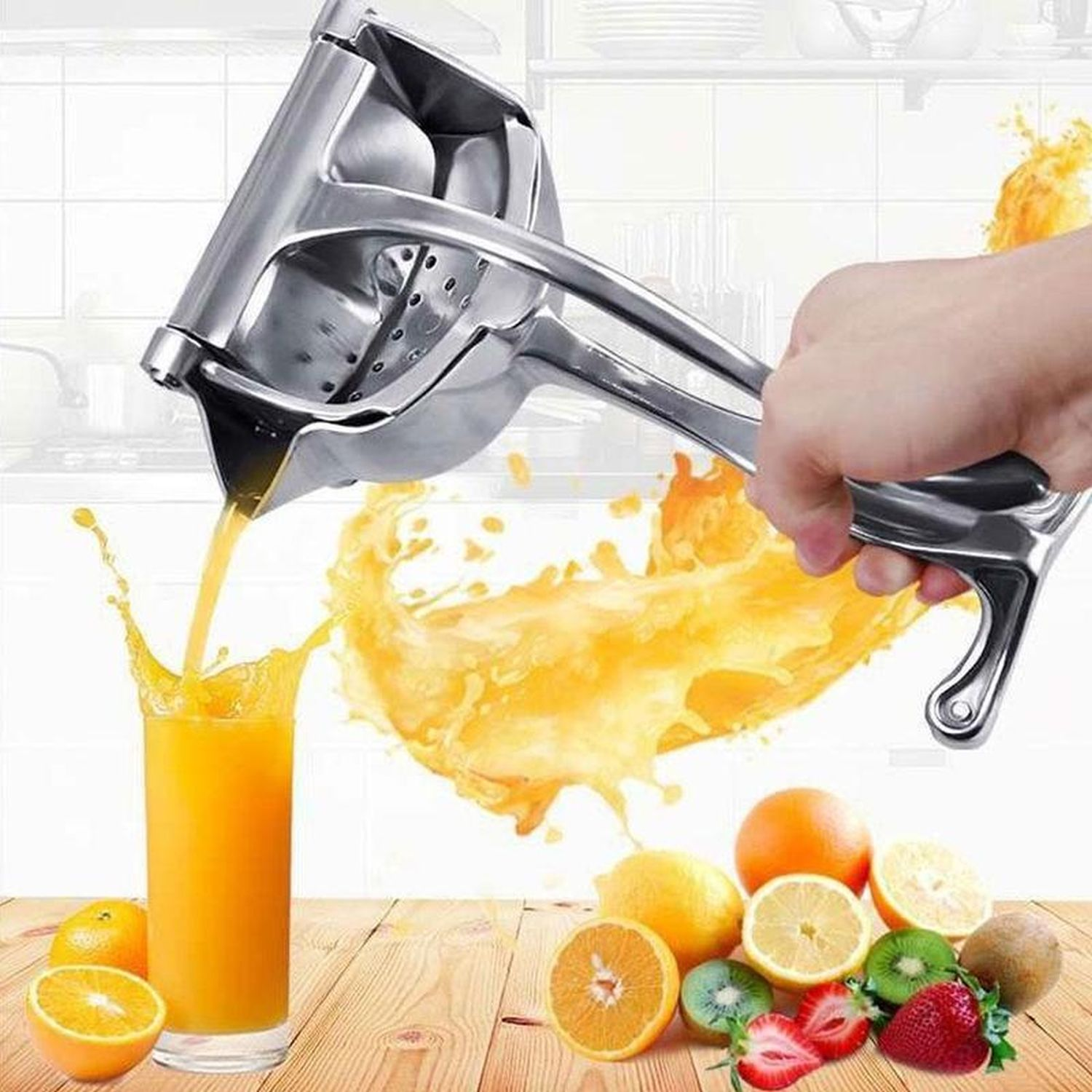 Eine silberne Saftpresse presst Orangensaft in ein Glas. Früchte liegen auf dem Tisch.